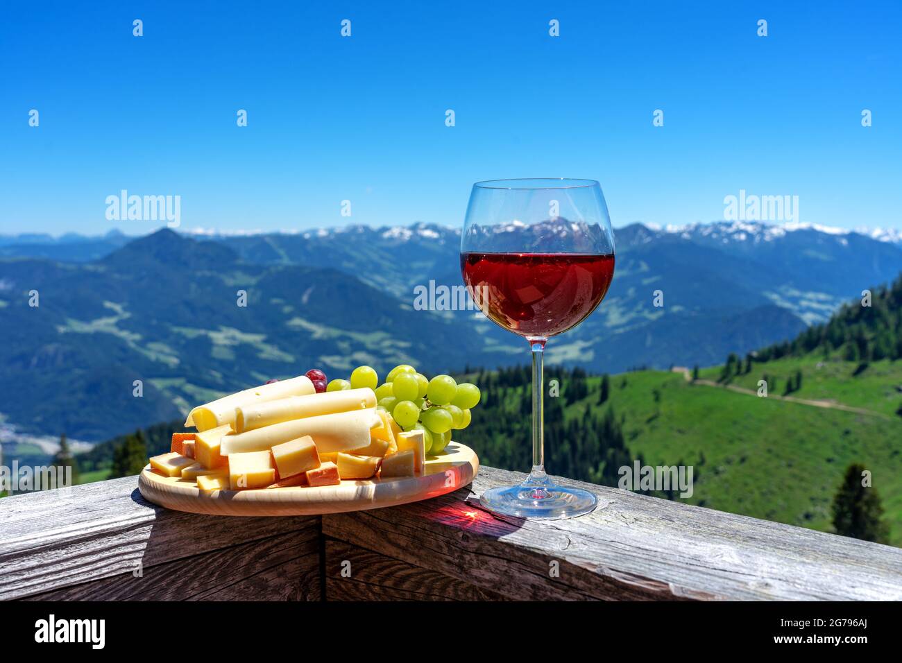 formaggio tirolo fresco con vino e uva sul paesaggio montano Foto Stock