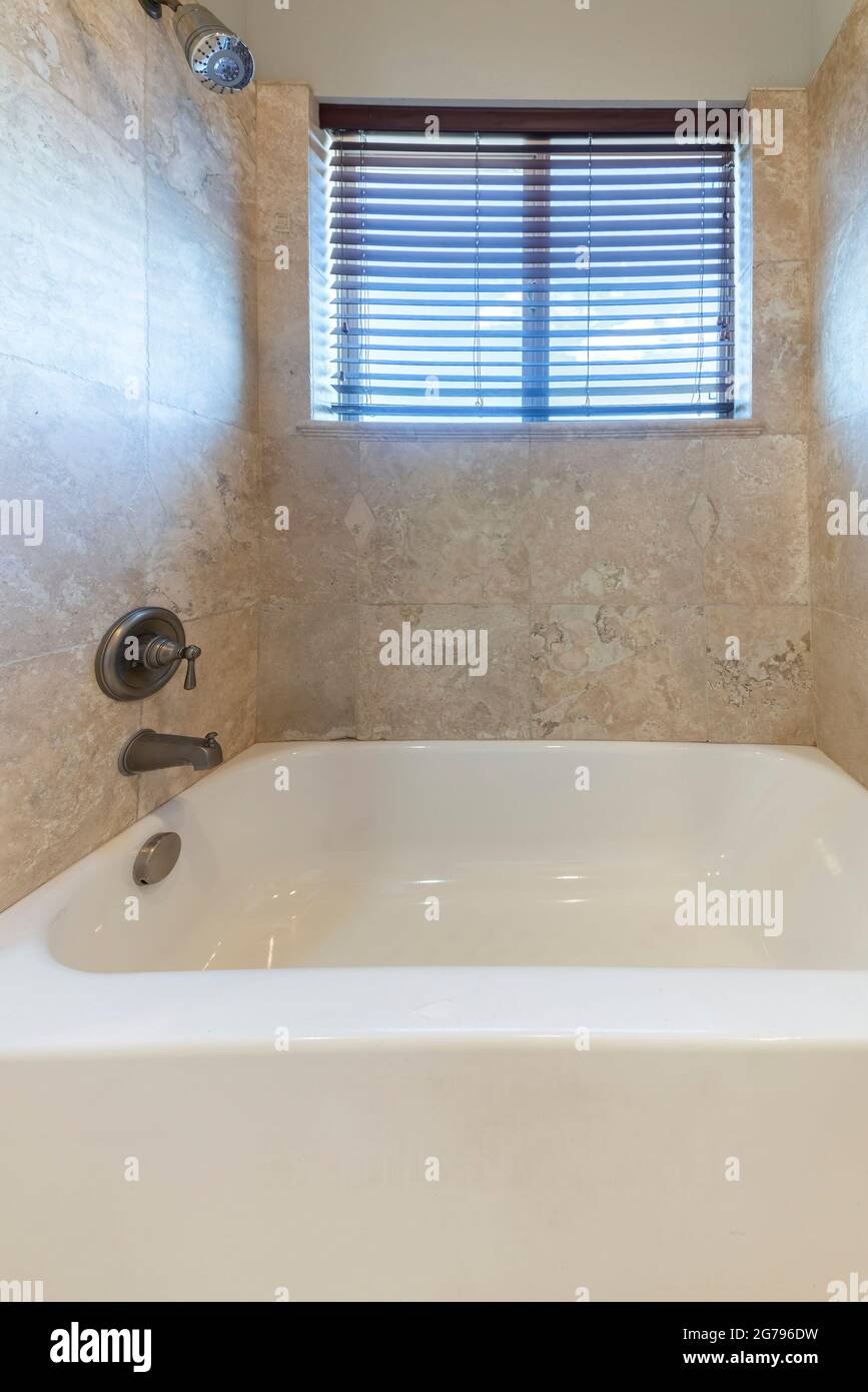 Bagno di piccole dimensioni con vasca in ceramica e doccia con soffione a parete e rubinetto Foto Stock