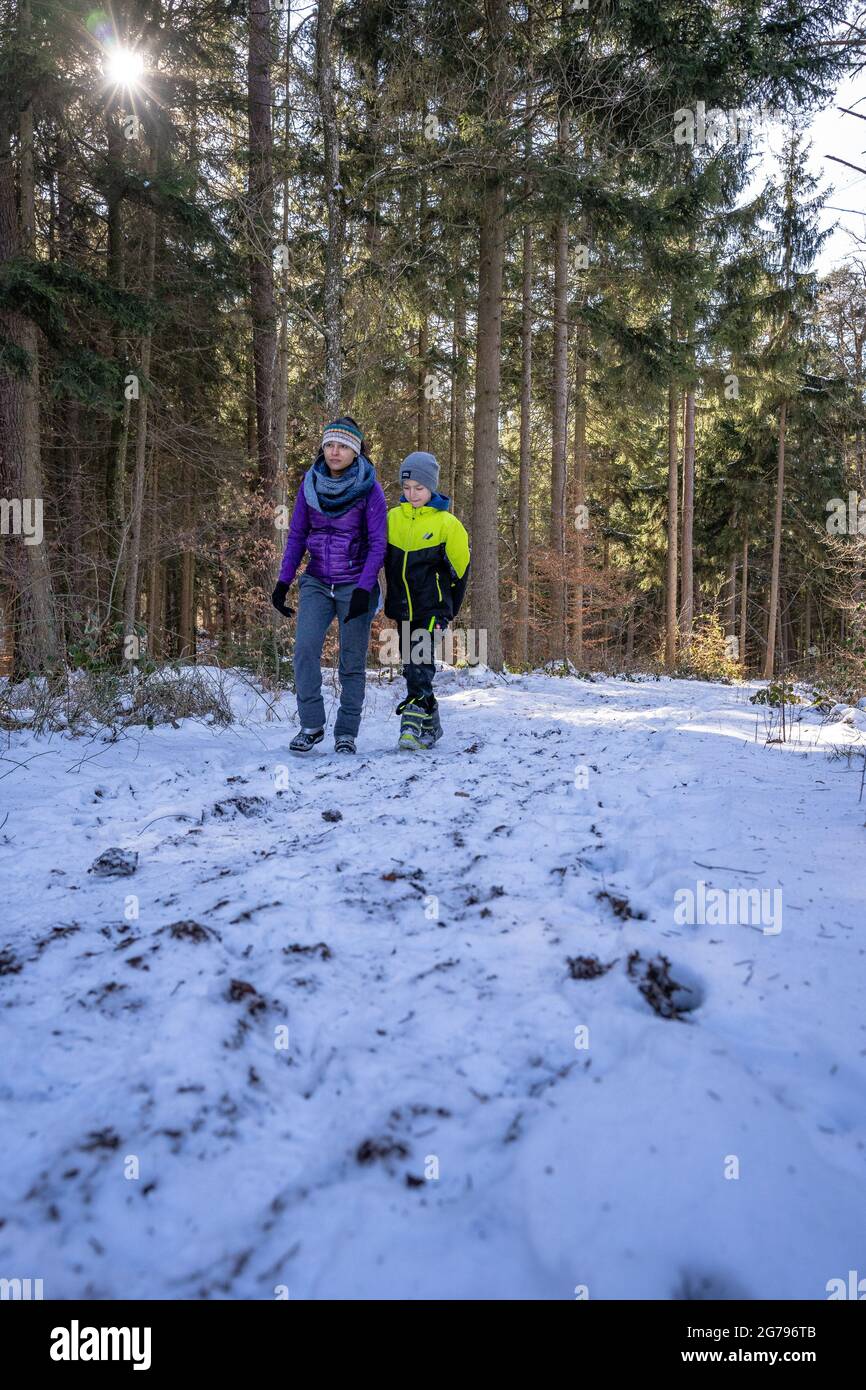 Europa, Germania, Baden-Wuerttemberg, Regione Schönbuch, Waldenbuch, Herzog-Jäger-Path, madre e figlio su un percorso forestale innevato Foto Stock