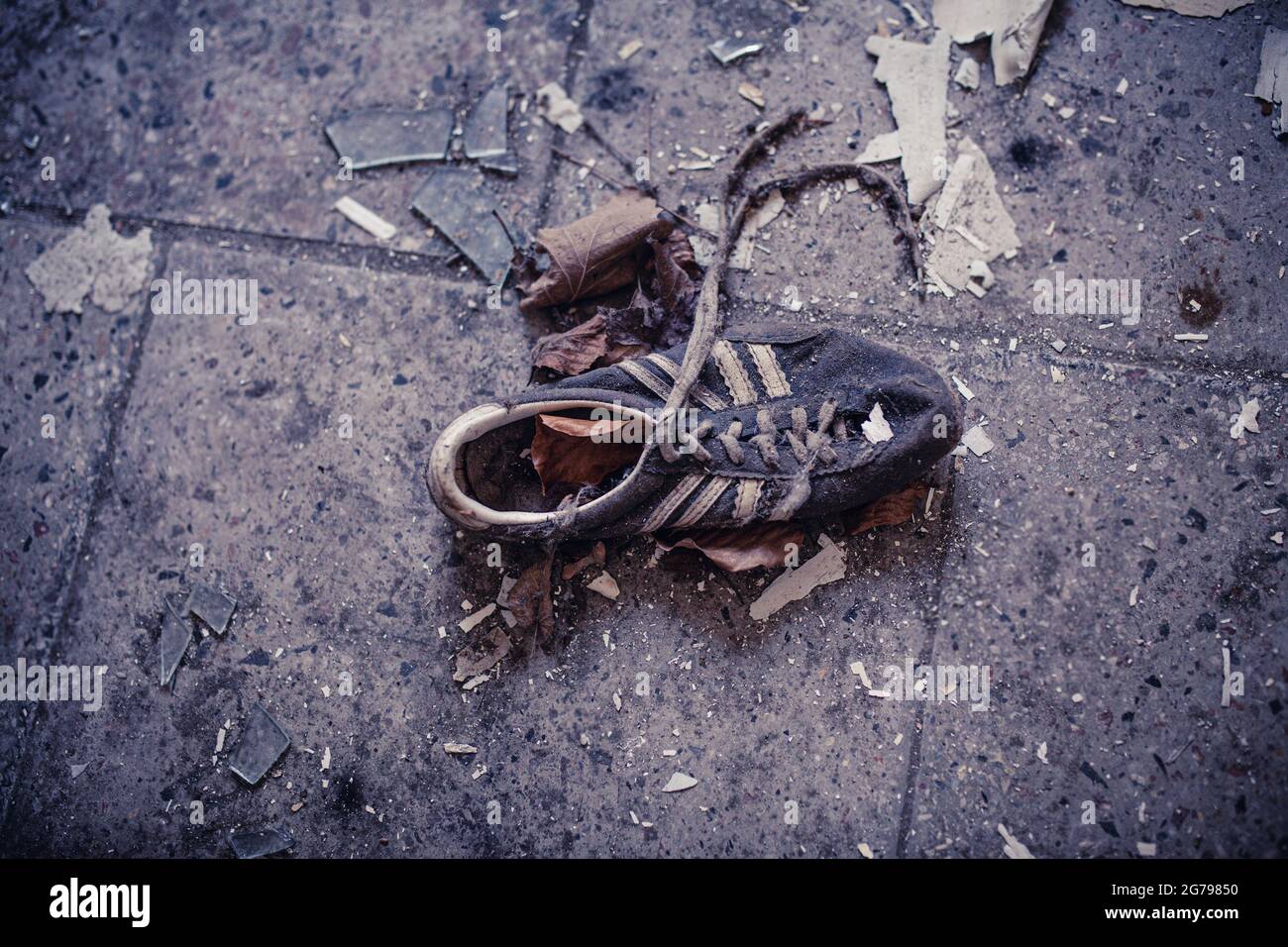 vecchia sneaker sul pavimento Foto Stock