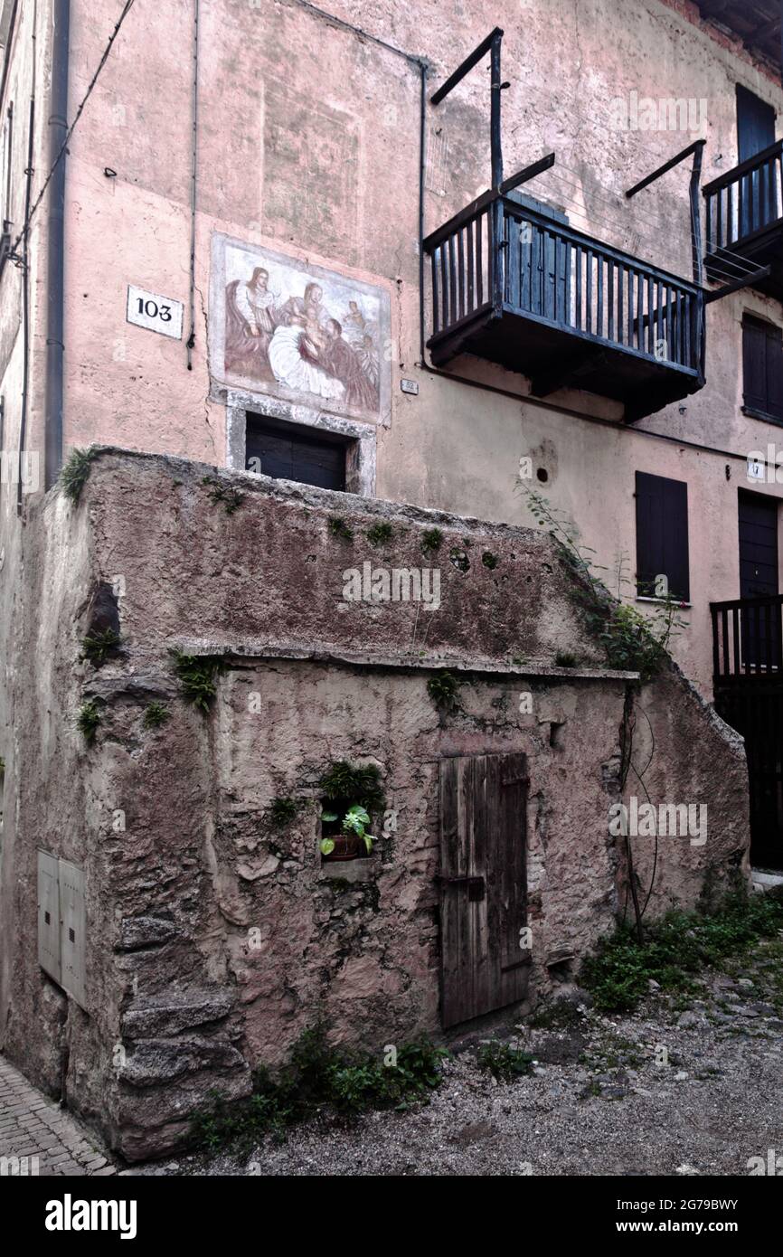 Murale religioso sulla facciata di una casa disabitata, decadimento urbano in Lombardia Foto Stock