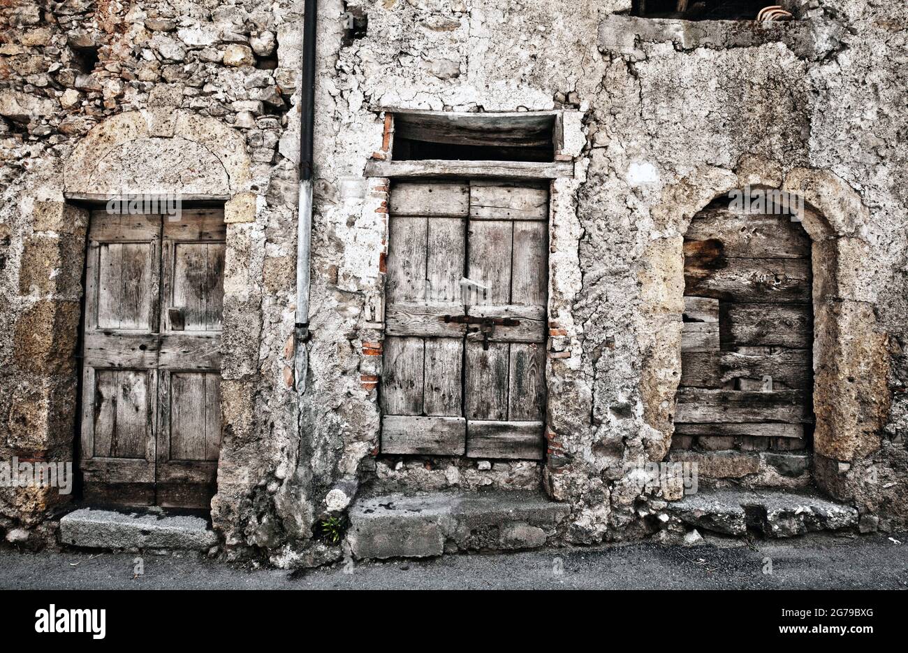 Decadimento urbano su casale in cava con porte in legno marcio, Lombardia Foto Stock