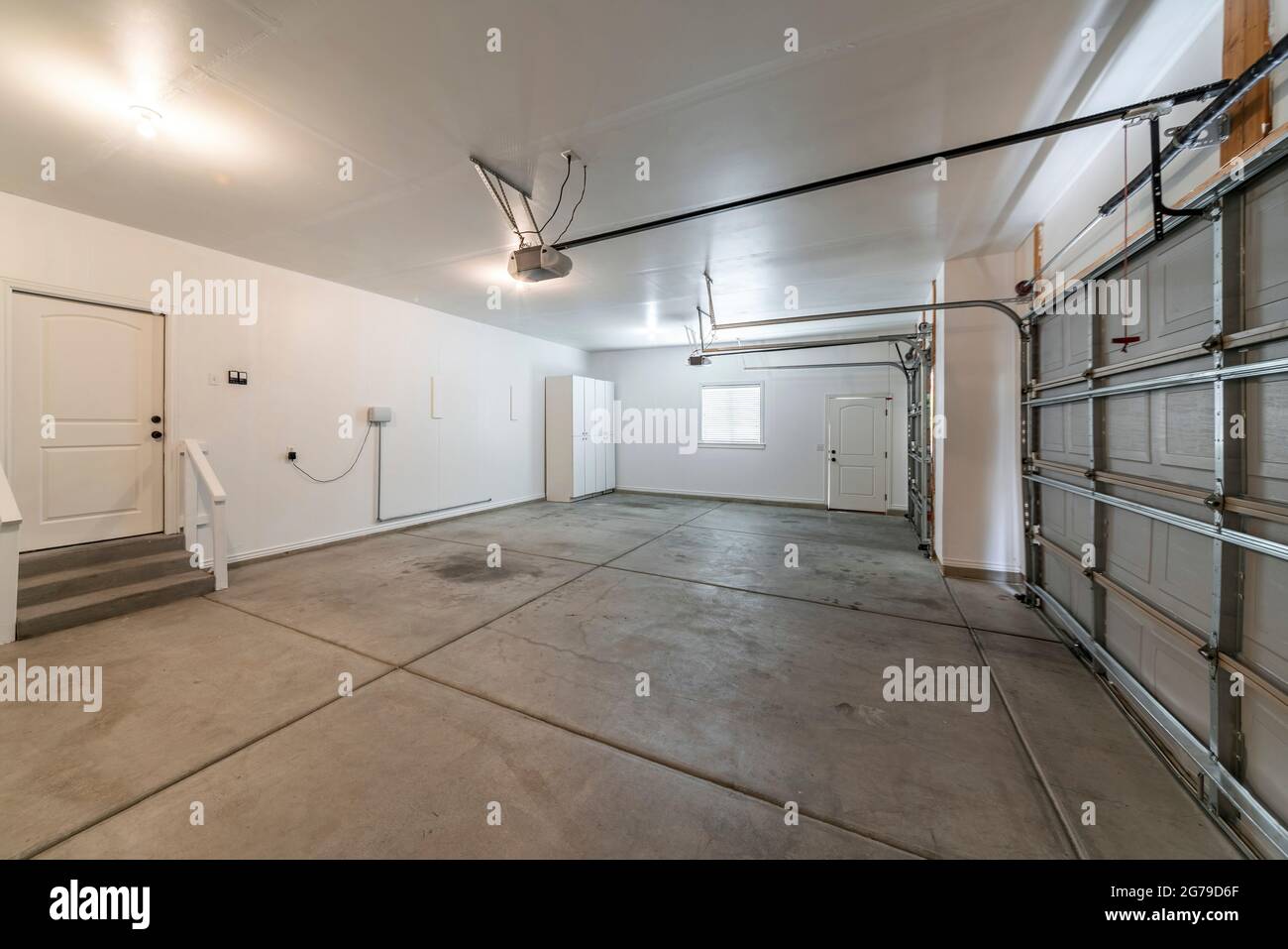 Interno di un garage con doppie porte automatiche e pavimento in cemento  Foto stock - Alamy