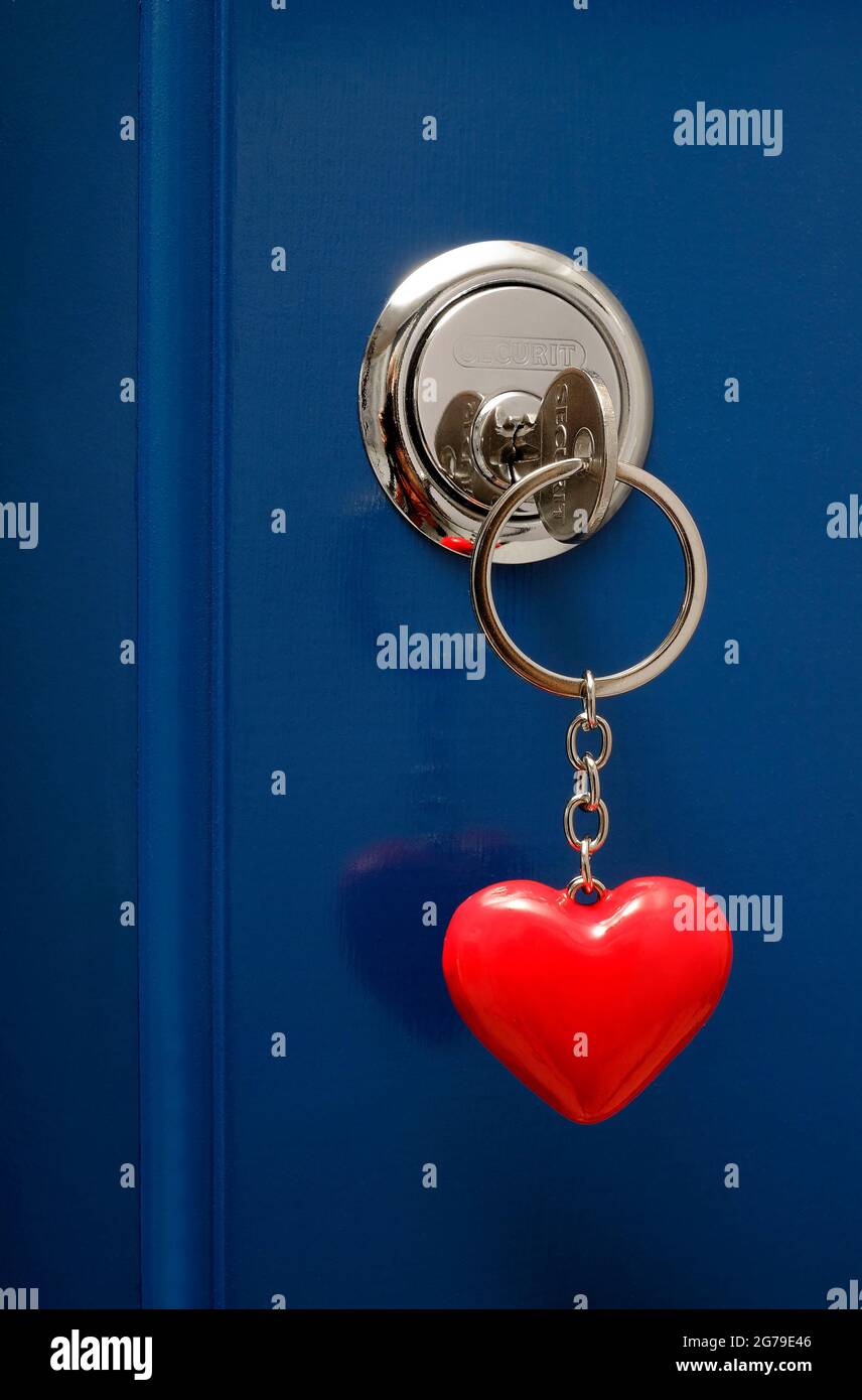 inserire la chiave sul portachiavi rosso a forma di cuore nella serratura della porta Foto Stock