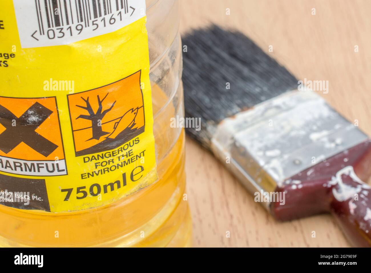 Molto vecchia, quasi vuota, bottiglia di spirito bianco del decoratore B&Q con pennello sul piano del tavolo. Etichetta sostanze pericolose e pittogrammi/icone tossici. Foto Stock