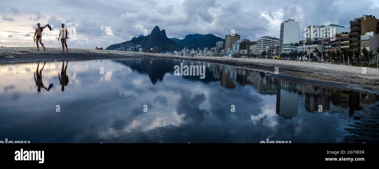 Grande puddle di acqua dopo la pioggia che riflette due fratelli montagna (Dois Irmaos) alla spiaggia di Ipanema/Leblon a Rio de Janeiro, Brasile. Leica M10 Foto Stock