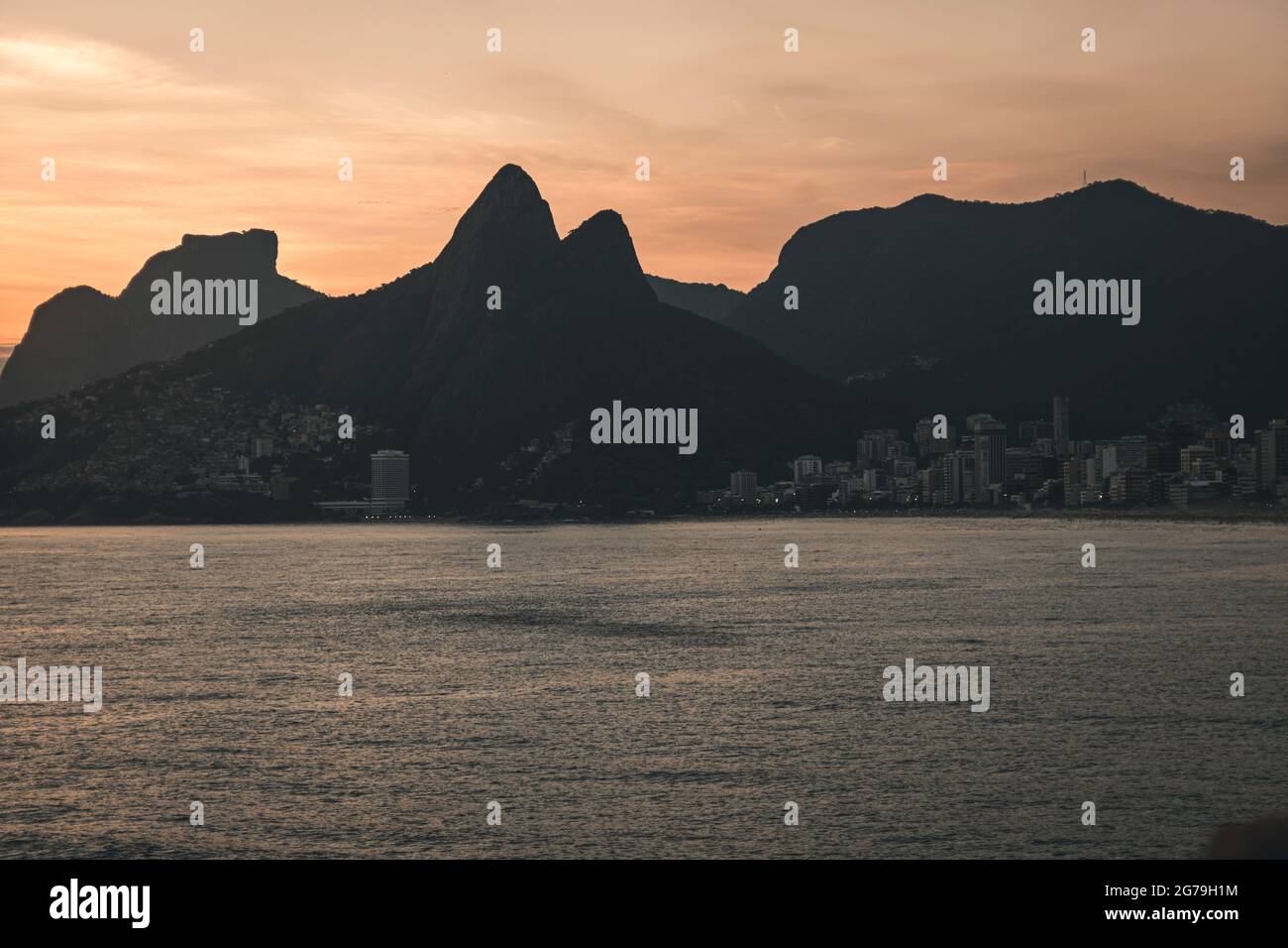 Un luogo magico: La gente applaude quando il sole tramonta alla roccia di Arpoador con vista della spiaggia di Ipanema e le montagne di Morro Dois Irmaos e Leblon nella parte posteriore. Macchina fotografica: Leica M10 Foto Stock