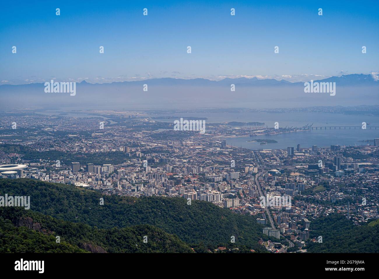 Goditi la spettacolare vista dalla cima del corcovado, poi la statua del cristo redentore nella baia di Guanabara in una giornata limpida con il cielo blu e le montagne sullo sfondo e l'Oceano Atlantico a Rio de Janeiro, Brasile, Sud America Foto Stock