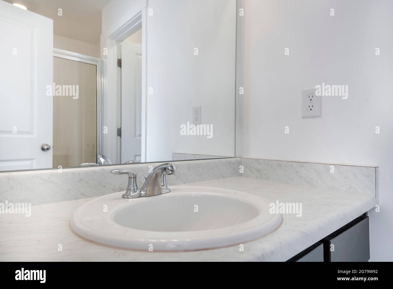 Lavandino singolo con ripiano in marmo bianco su un bagno bianco Foto Stock