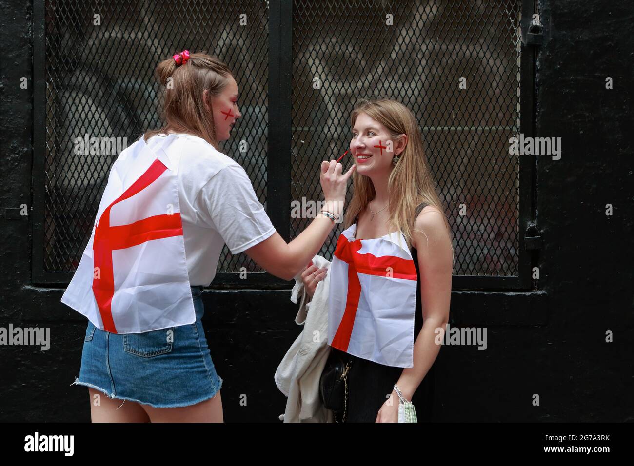 Londra (UK), 11 luglio 2021: Due tifosi inglesi Euro 2020 dipingono a vicenda i volti prima di fare la loro strada per guardare i versetti inglesi Foto Stock