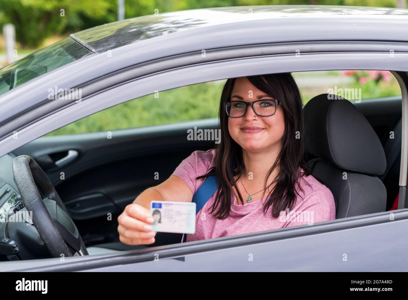 La giovane donna mostra con orgoglio la patente di guida Foto Stock