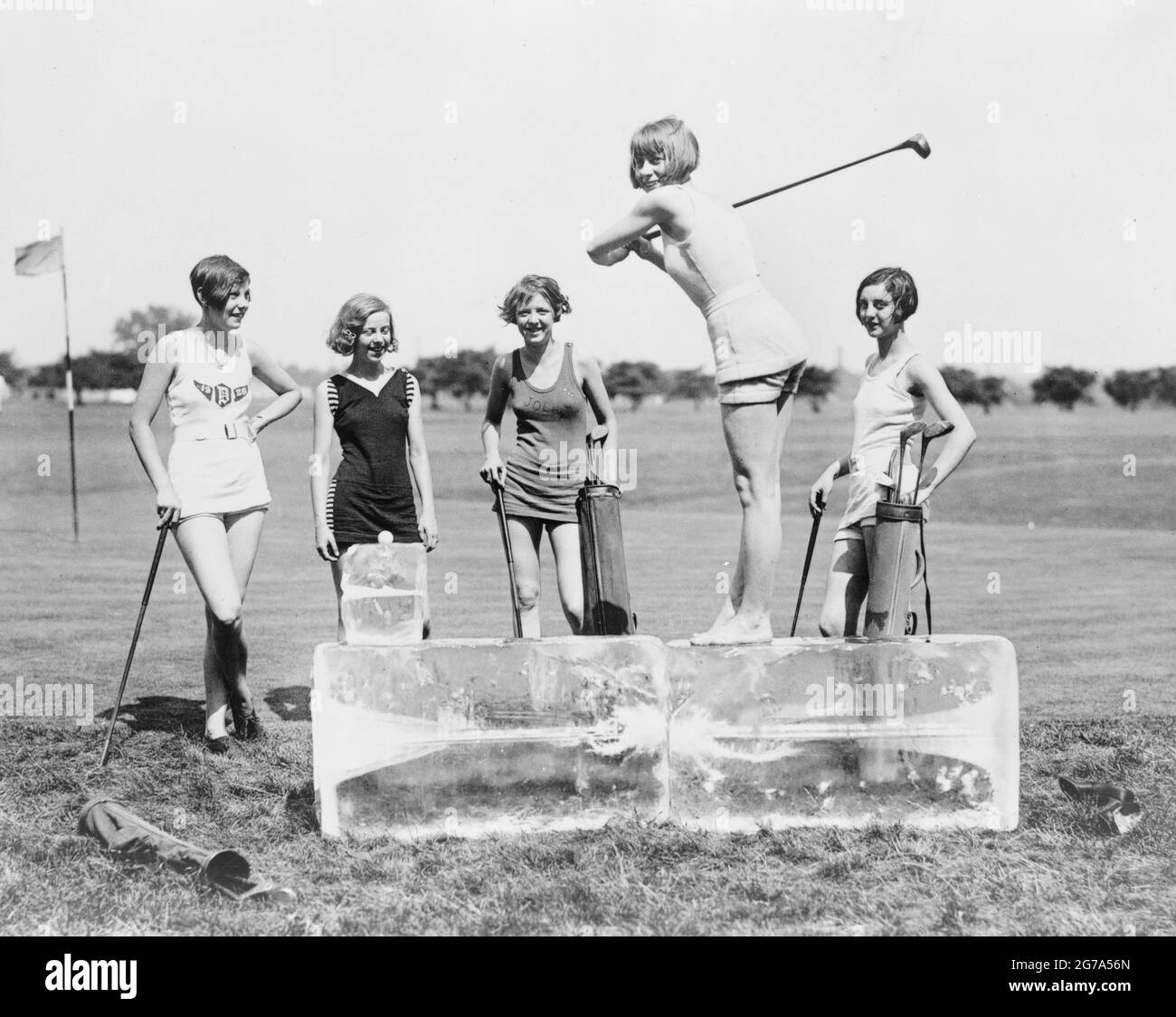Fotografia vintage intitolata gling off at the Tee - cinque donne che godono di una partita di golf con stratagemma unico per affrontare l'effetto riscaldamento globale. Foto Stock