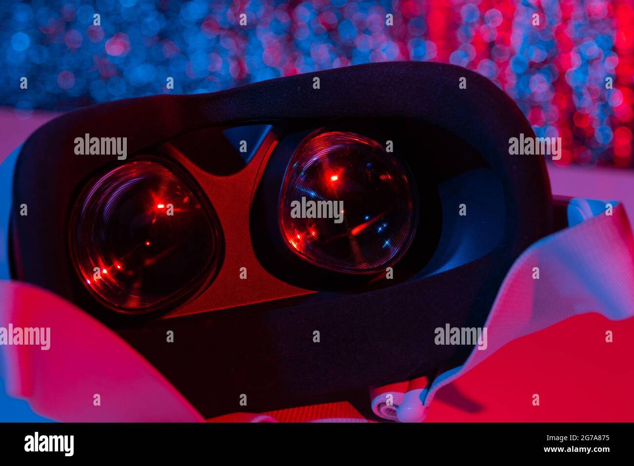 Casco per realtà virtuale su sfondo bianco con luce al neon. Realtà virtuale, futuro, gadget, concetto di tecnologia. Foto Stock