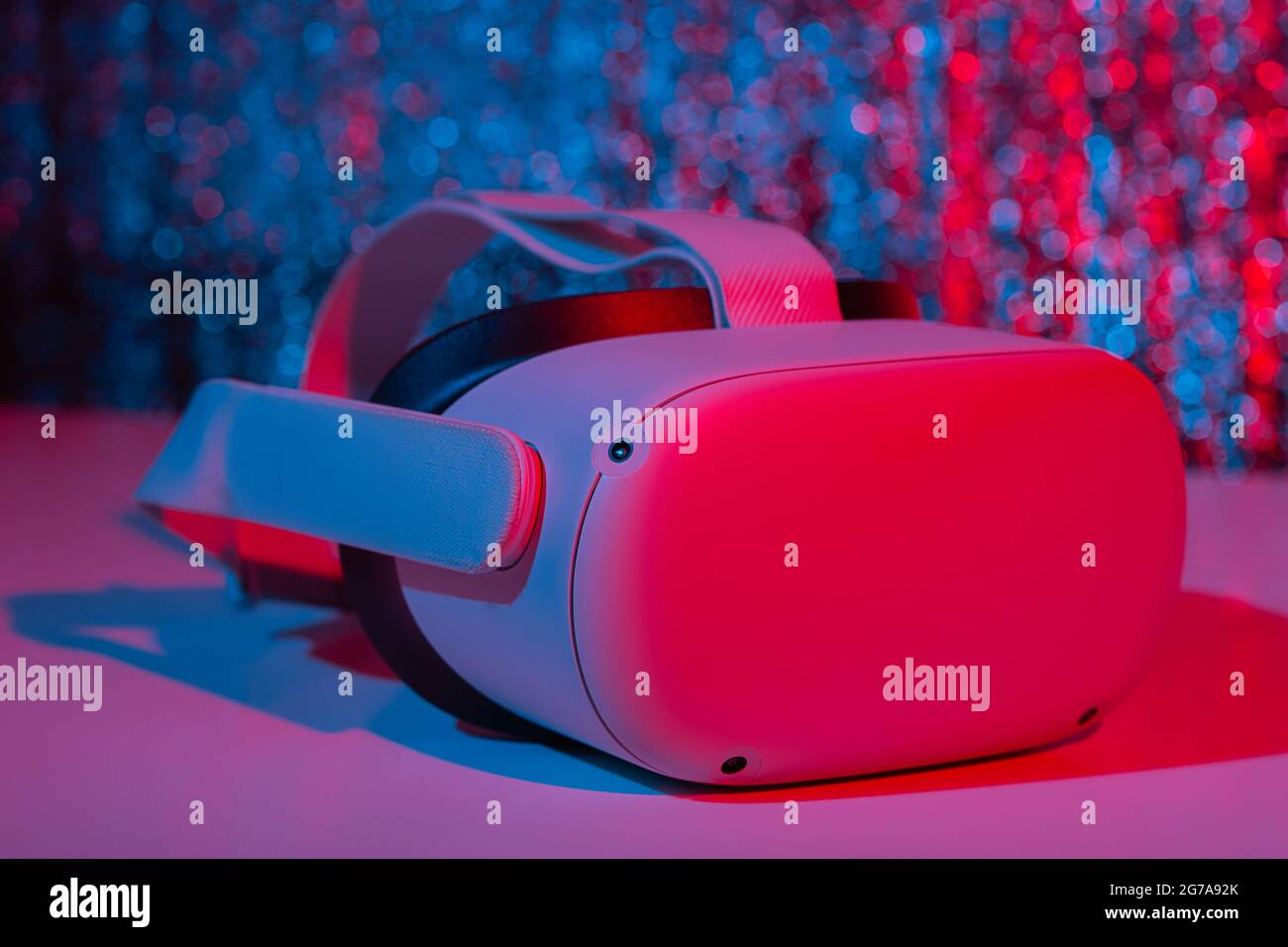 Casco per realtà virtuale su sfondo bianco con luce al neon. Realtà virtuale, futuro, gadget, concetto di tecnologia. Foto Stock