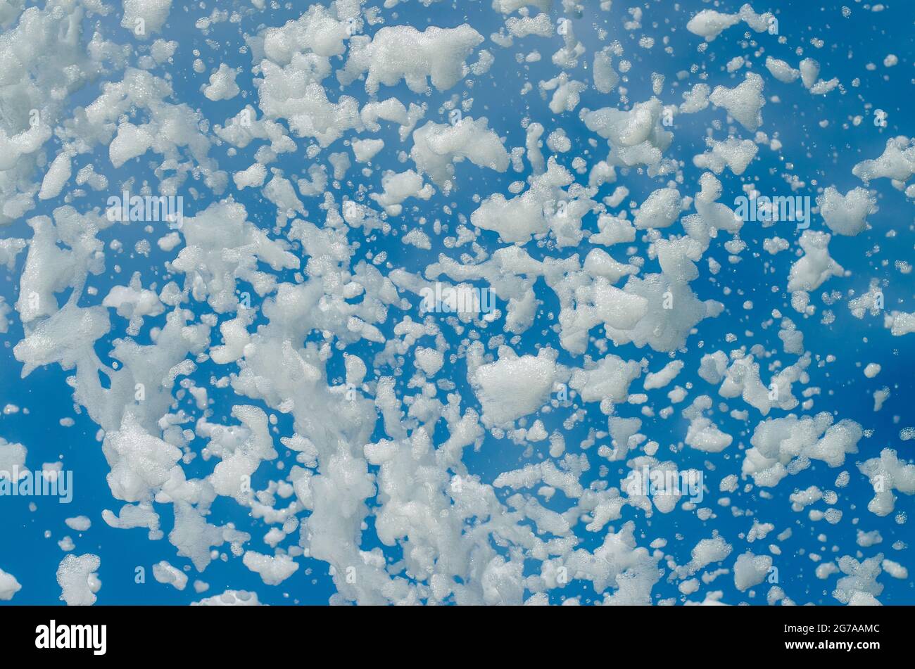 schiuma di sapone bianco volante e cielo blu Foto Stock