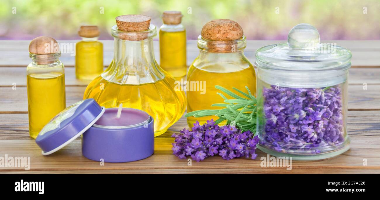 Fiori di lavanda e olio su tavola di legno Foto Stock