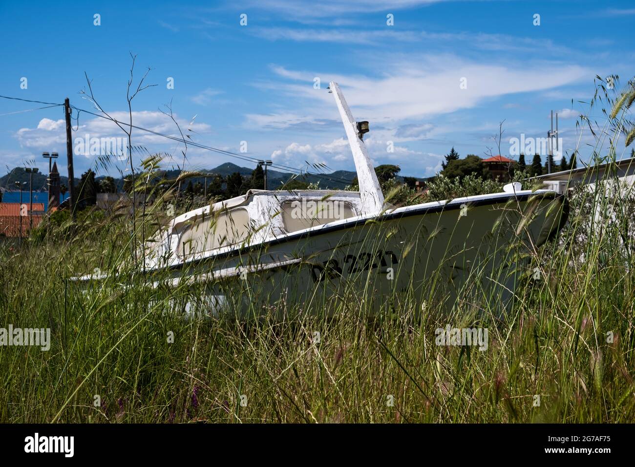 Piccola barca a terra e immagazzinata in un lungo campo di erba sull'isola di Lopud in Croazia. 2021 Foto Stock