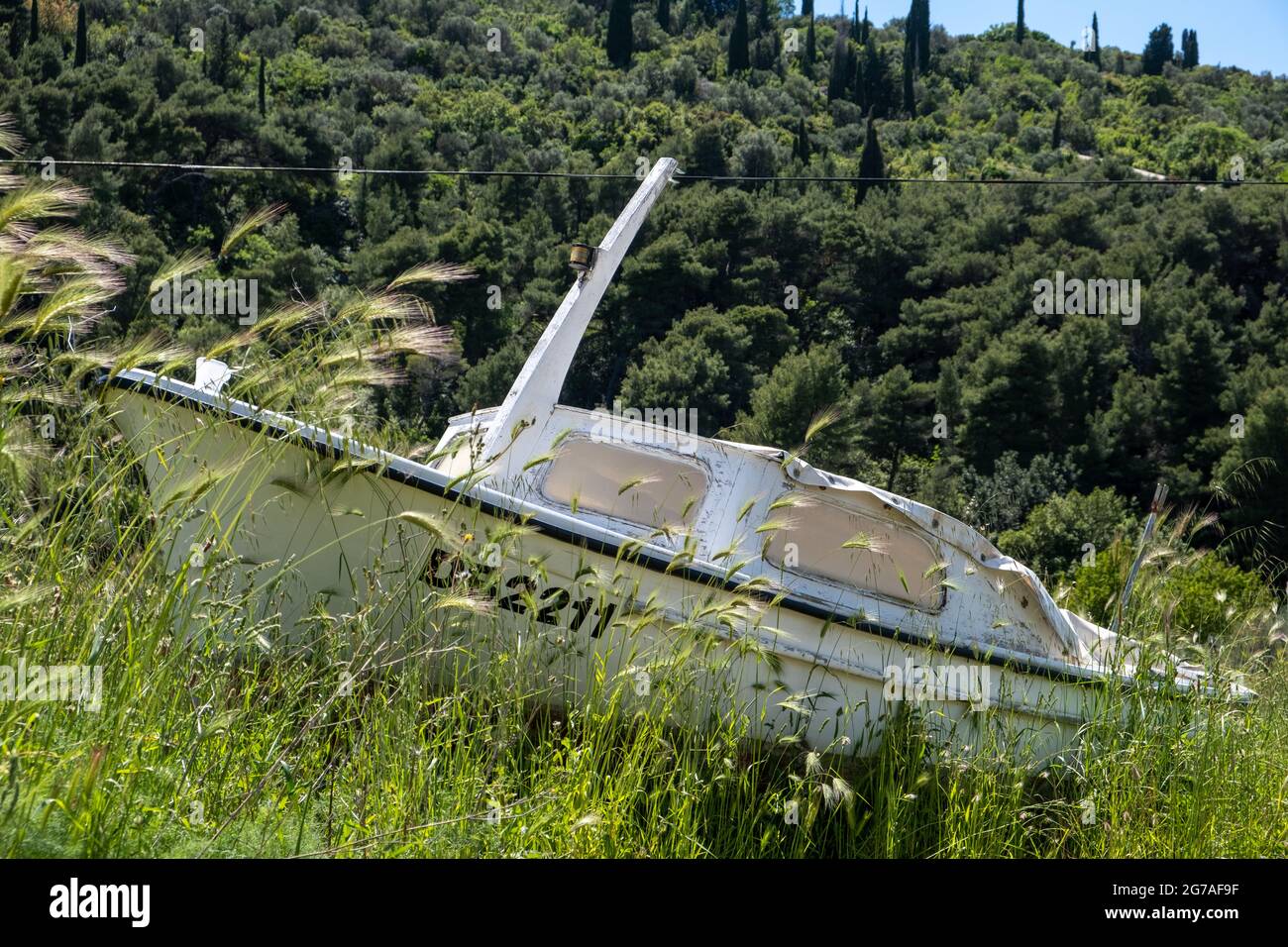 Piccola barca a terra e immagazzinata in un lungo campo di erba sull'isola di Lopud in Croazia. 2021 Foto Stock