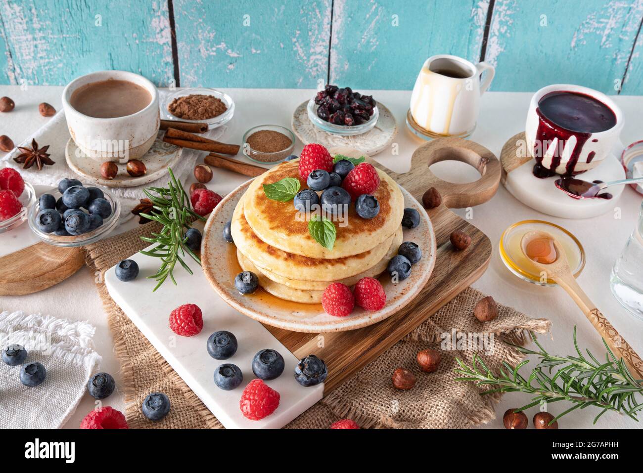 Frittelle con sciroppo d'acero, mirtilli e lamponi per colazione Foto Stock