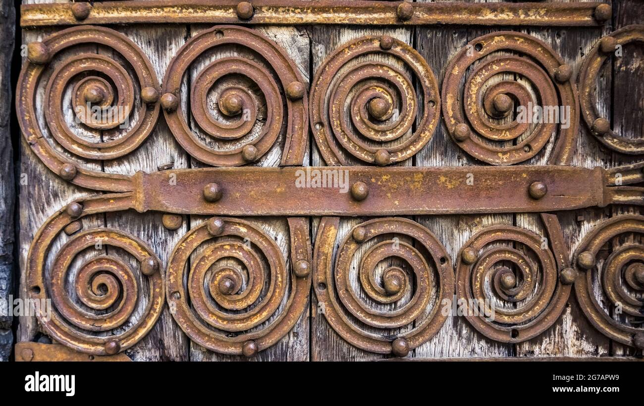 Accessori per porte a spirale sul portale romanico dell'Église Saint Martin a Palalda vicino ad Amélie les Bain. La chiesa fu costruita nel XII secolo. Foto Stock