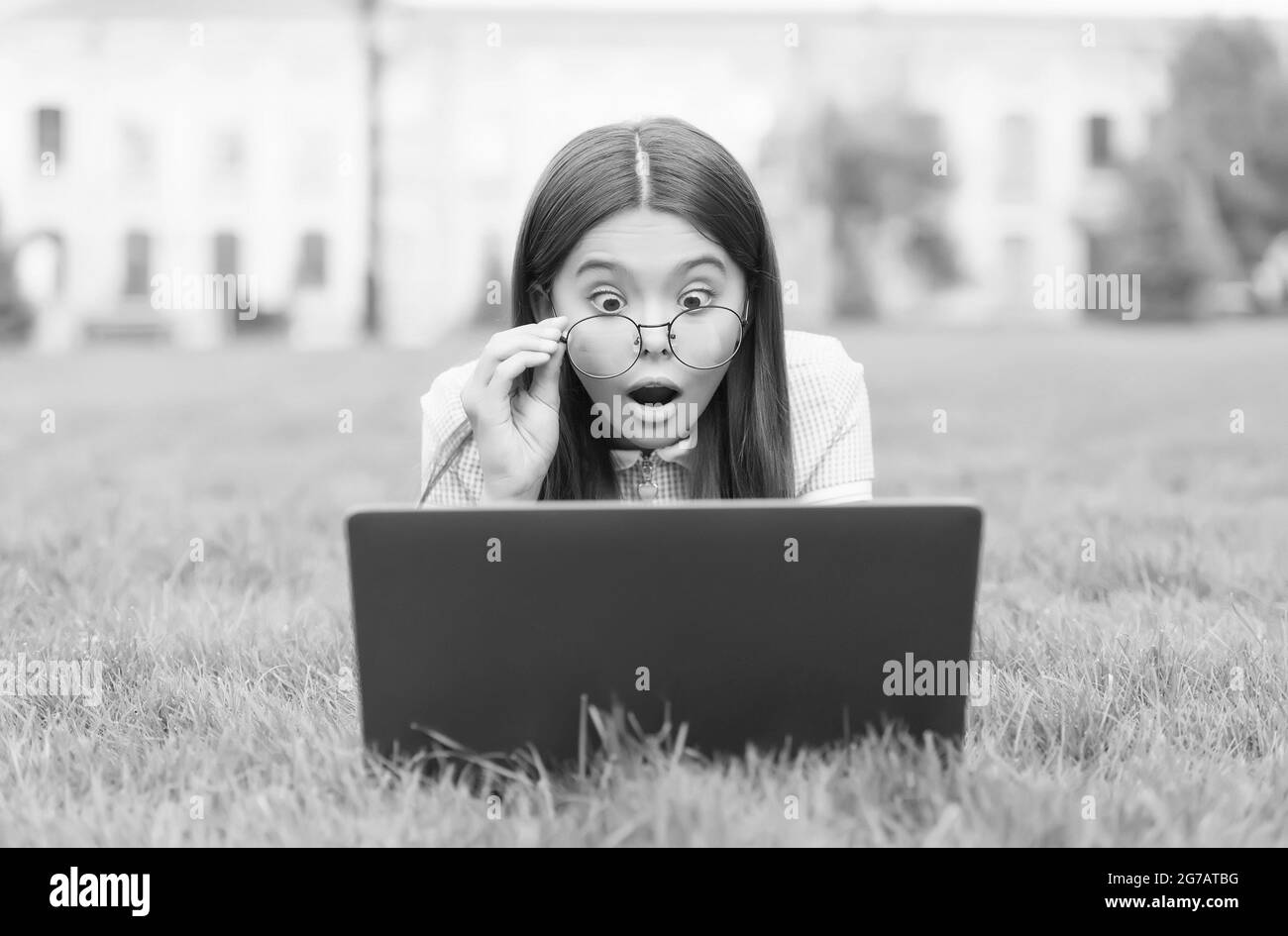 Scioccato e sorpreso capretto su Internet con il calcolatore digitale si sentono stupiti circa fare un errore nell'istruzione scolastica, amazemen Foto Stock