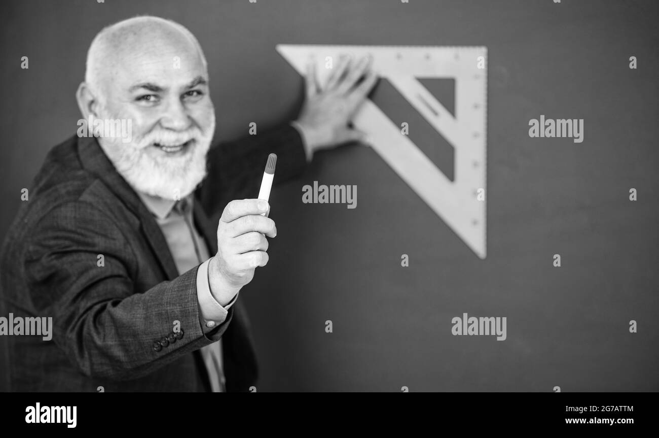 sei il prossimo. soggetto preferito. insegnante di uomo anziano usare lo strumento di triangolo matematico. uomo tutor sopportato al blackboard. torna a scuola. Concetto di matematica con Foto Stock