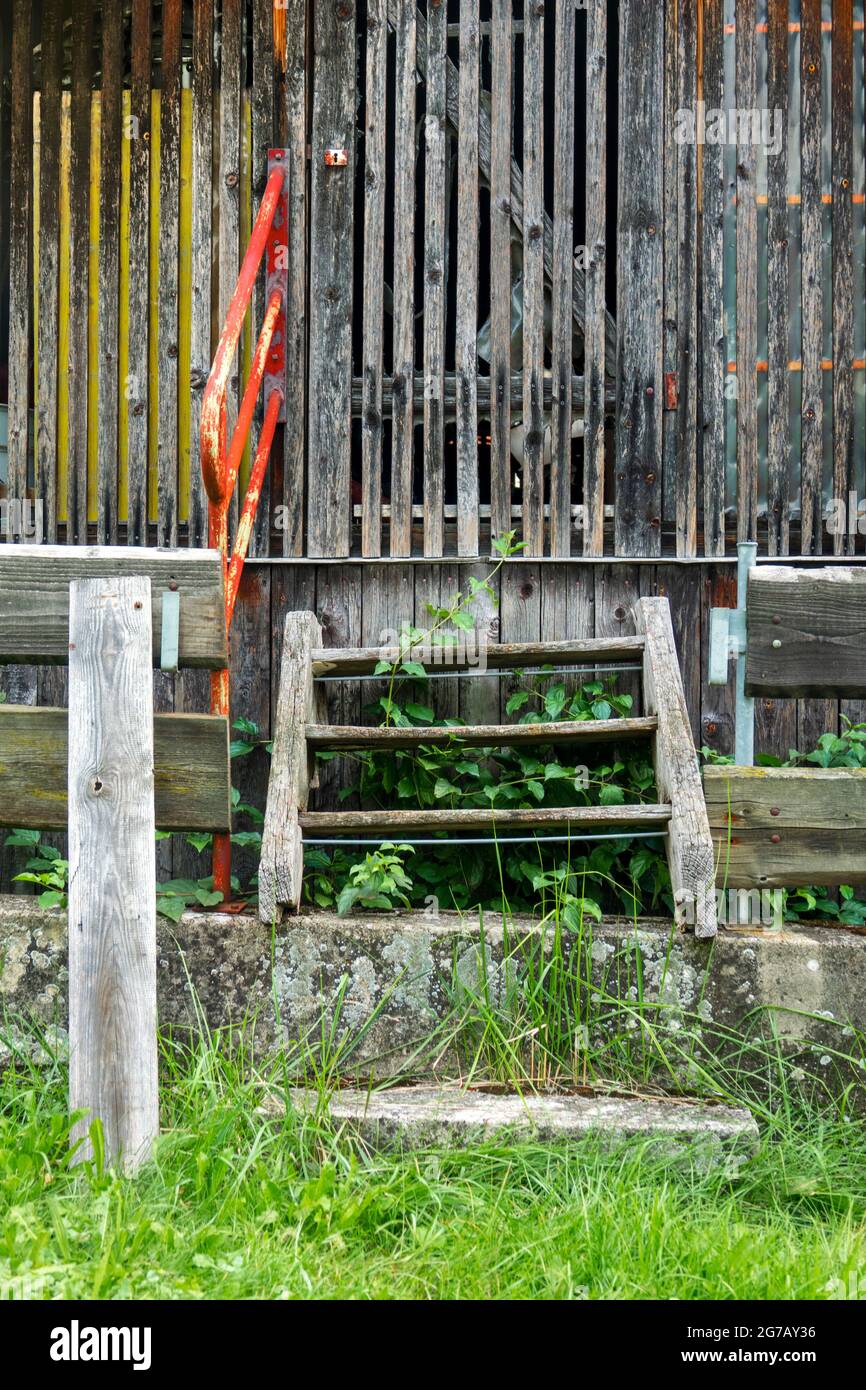 Germania, Baden-Wuerttemberg, Neckartenzlingen, scale, ringhiera rossa, porta, capannone vecchio a doghe Foto Stock