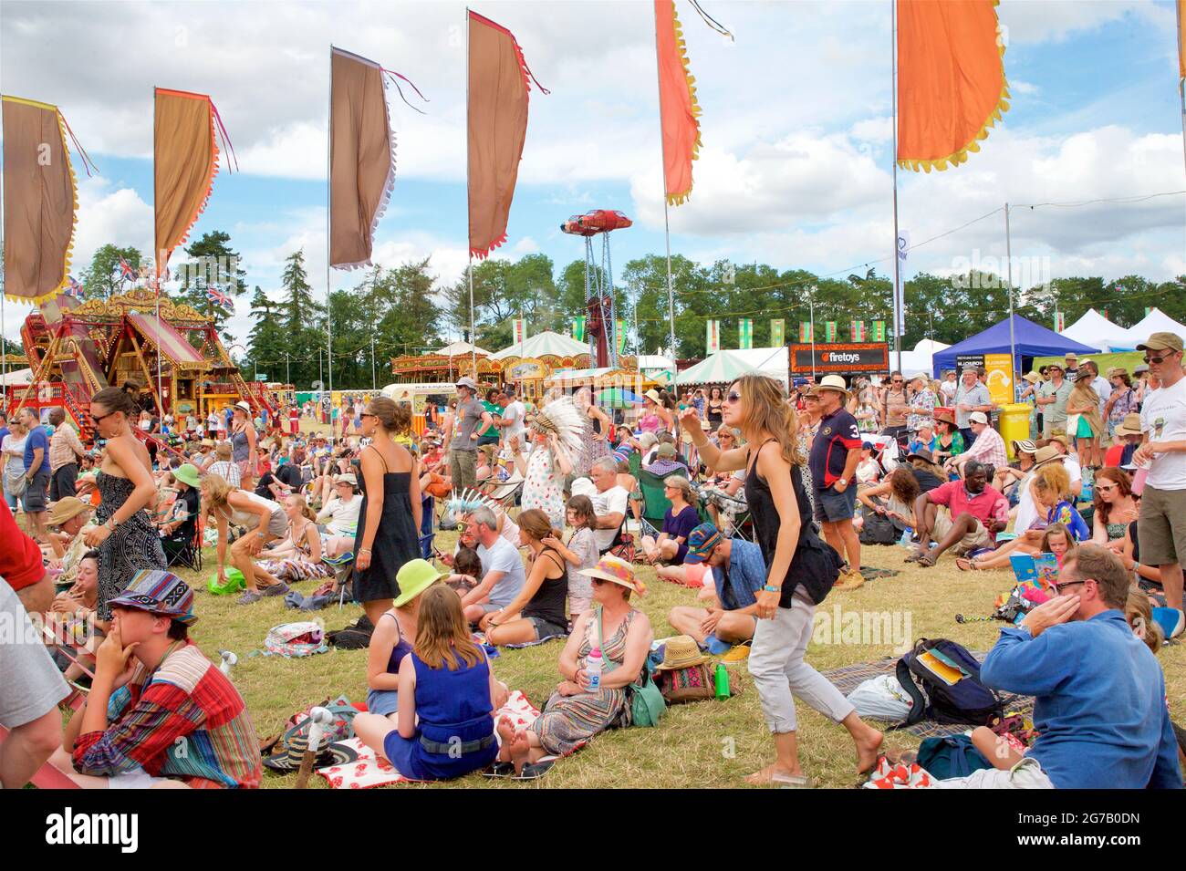 Festivalgoers godendo del sole estivo in un gestival in Inghilterra. Womad festival, Chharlton Park, Malmesbury Wiltshire Foto Stock