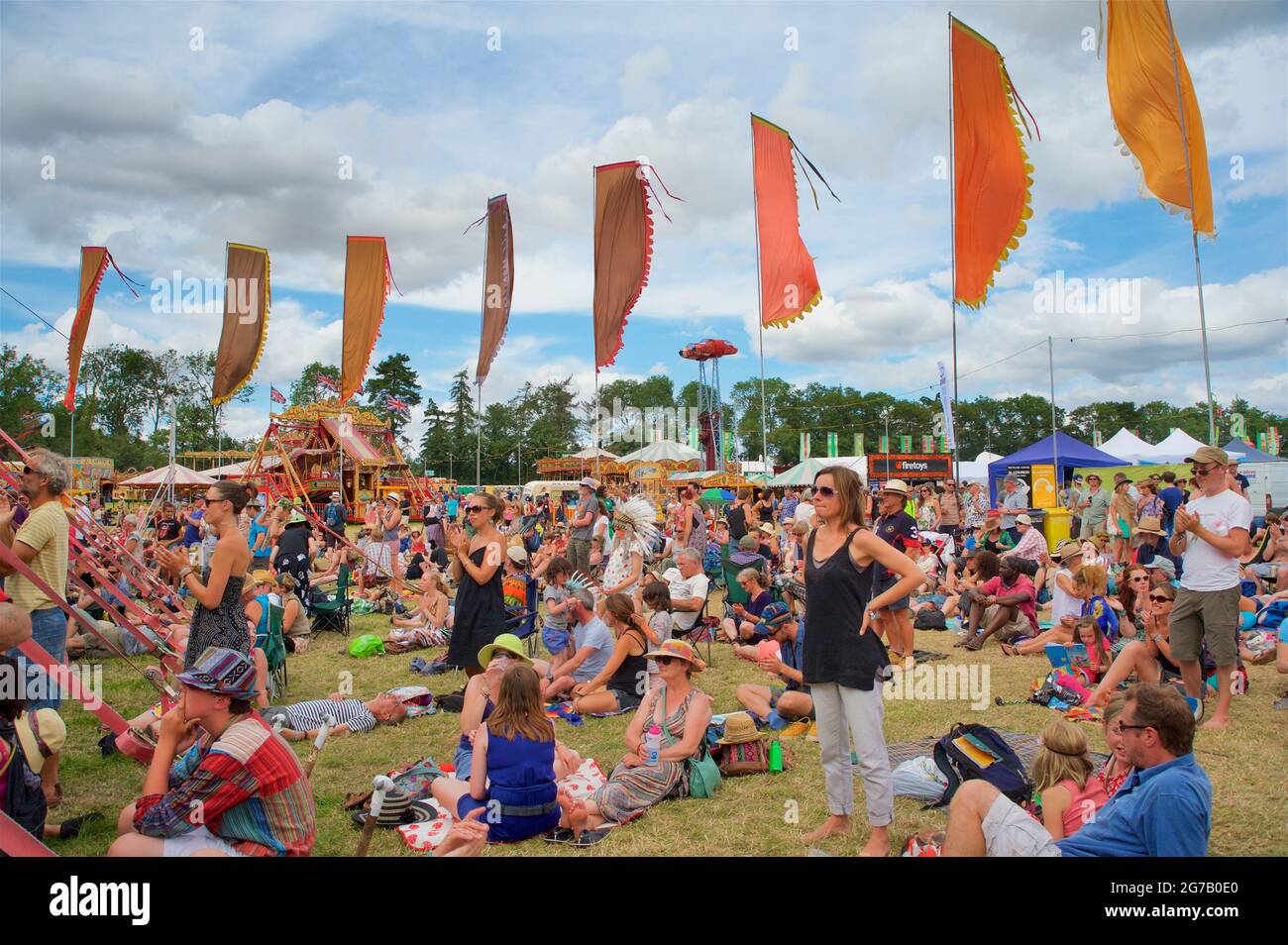 Festivalgoers godendo del sole estivo in un gestival in Inghilterra. Womad festival, Chharlton Park, Malmesbury Wiltshire Foto Stock