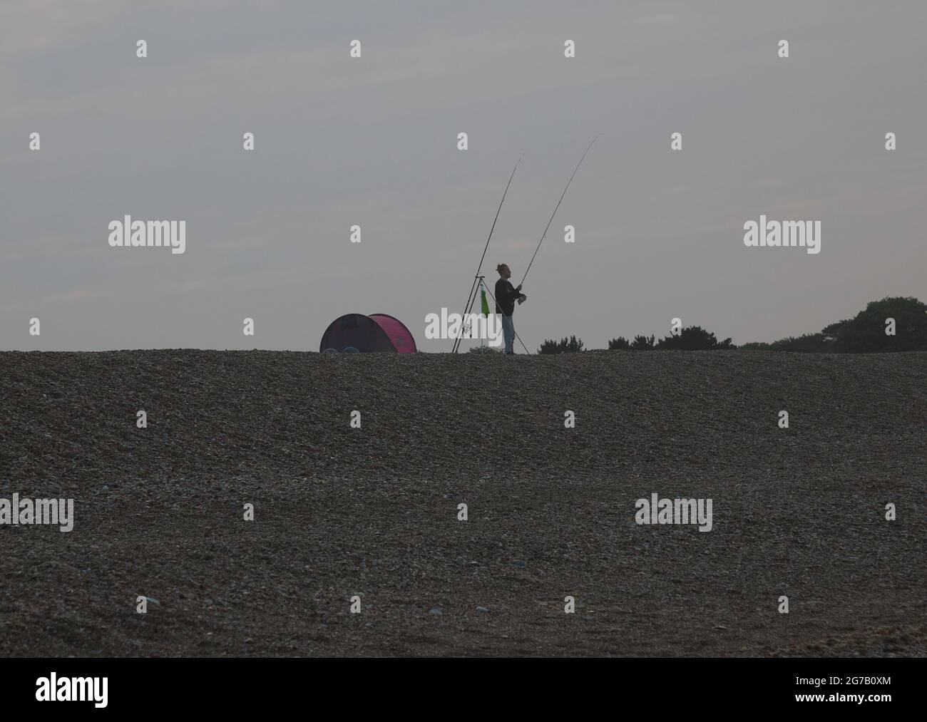 Beach angler visto sulla spiaggia in Inghilterra, Regno Unito nell'estate 2021. Foto Stock