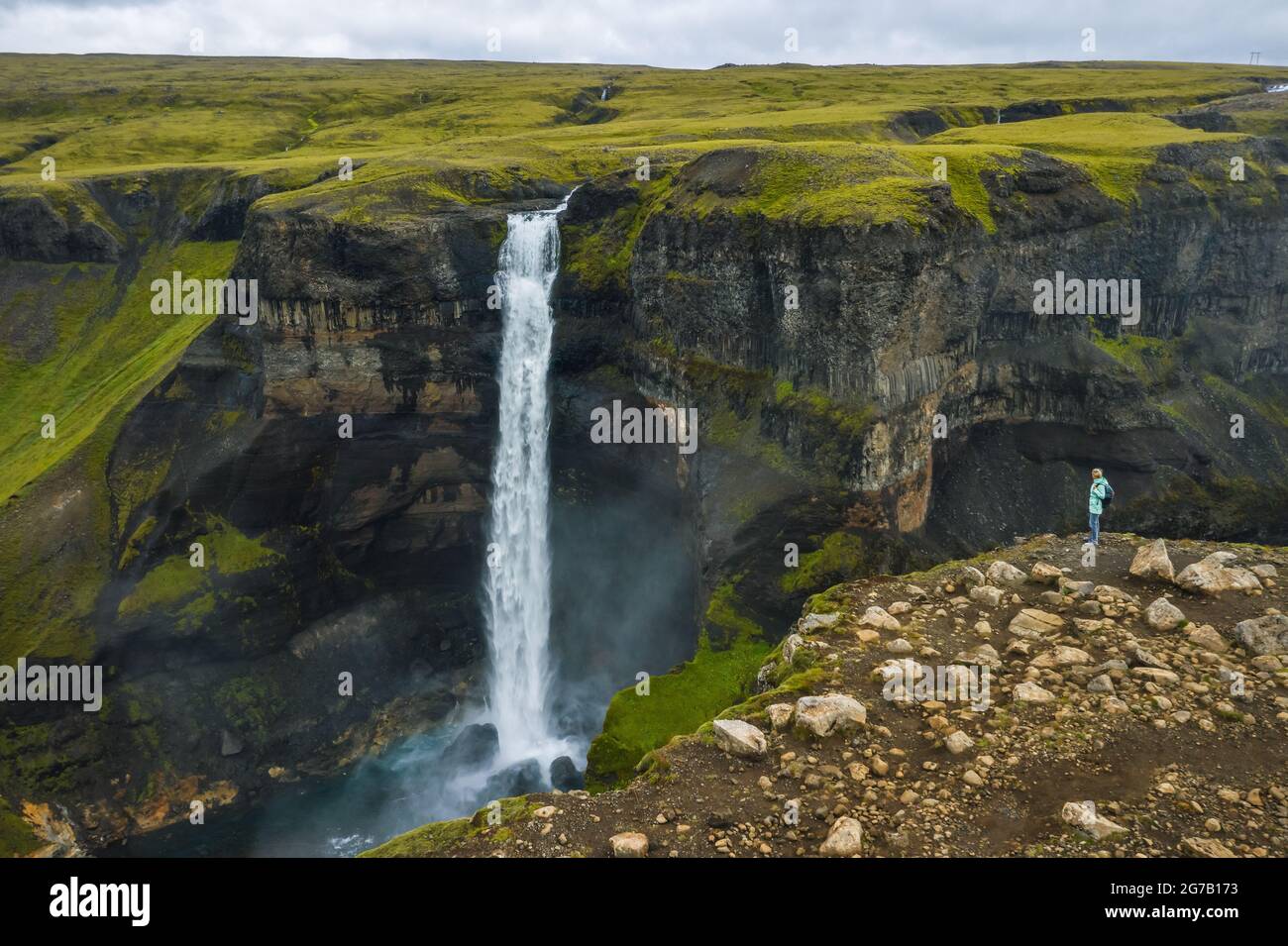 Vista aerea di una donna con zaino godendo la cascata di Haifoss delle Highlands Islanda Foto Stock