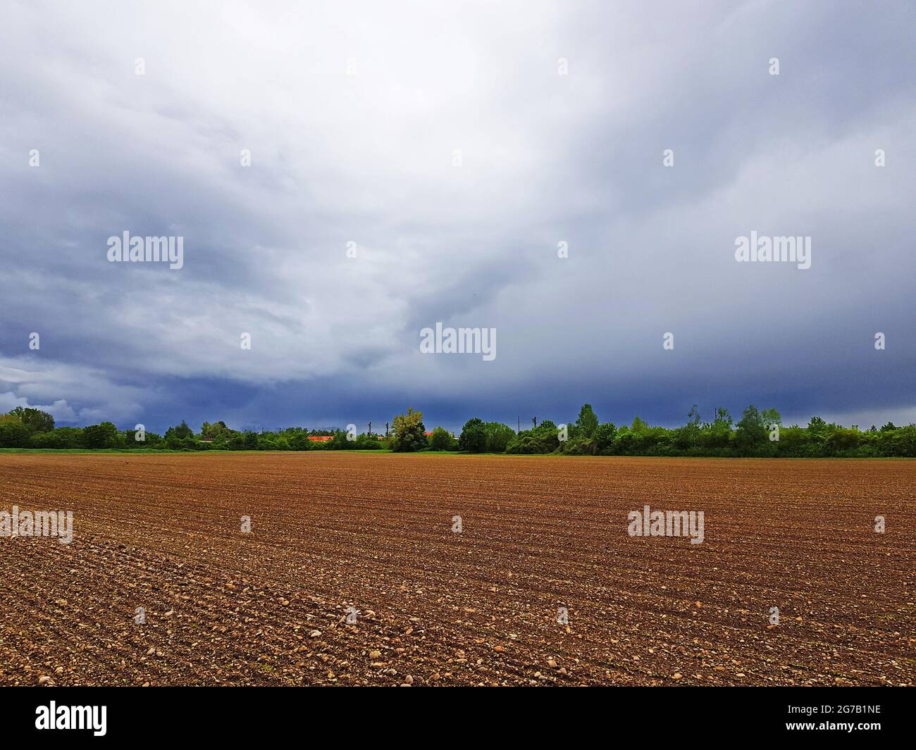 Cielo con nuvole scure su un paesaggio arabile Foto Stock