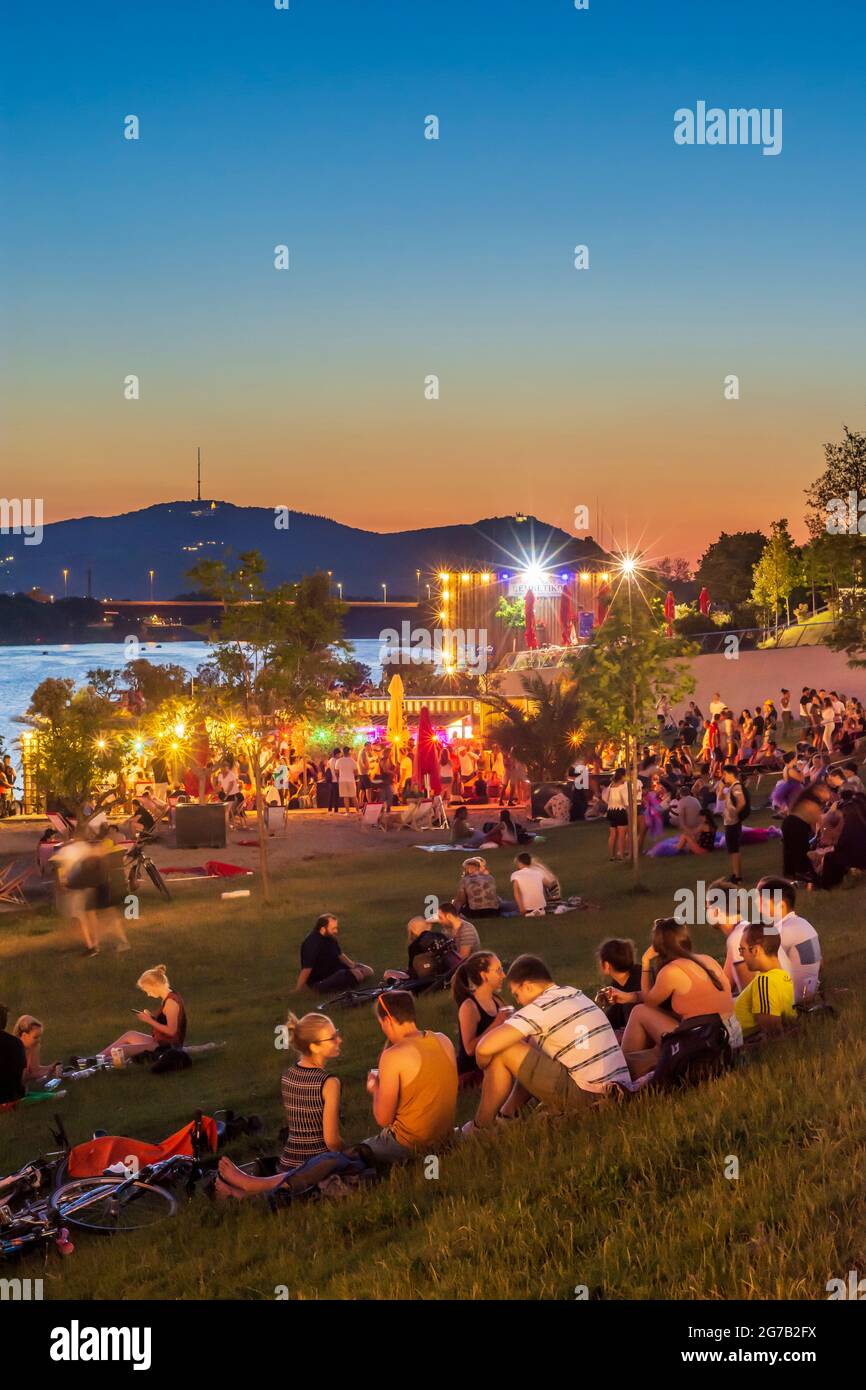 Vienna, area ricreativa Copa Beach sul fiume Neue Donau (nuovo Danubio), persone sul prato, bar, vista su Wienerwald nel 22. Donaustadt, Vienna, Austria Foto Stock