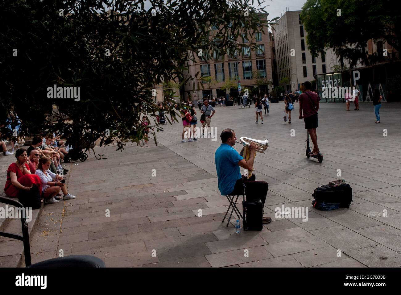 Barcellona, Spagna. 12 luglio 2021, Barcellona, Spagna: L'uomo suona musica per i pendolari nel centro di Barcellona. La Spagna è tra i paesi dell'UE con il più alto tasso di infezione da coronavirus, alcune regioni stanno imponendo misure per fermare la rapida diffusione della variante del Delta COVID-19 che colpisce principalmente la popolazione giovane. Nonostante ciò, la presenza di turisti viene rimmarcavata in luoghi come Barcellona, dove la dipendenza finanziaria dal turismo e dall'industria dei viaggi sta facendo decisioni prioritarie a favore dell'economia. Credit: Jordi Boixareu/Alamy Live News Foto Stock