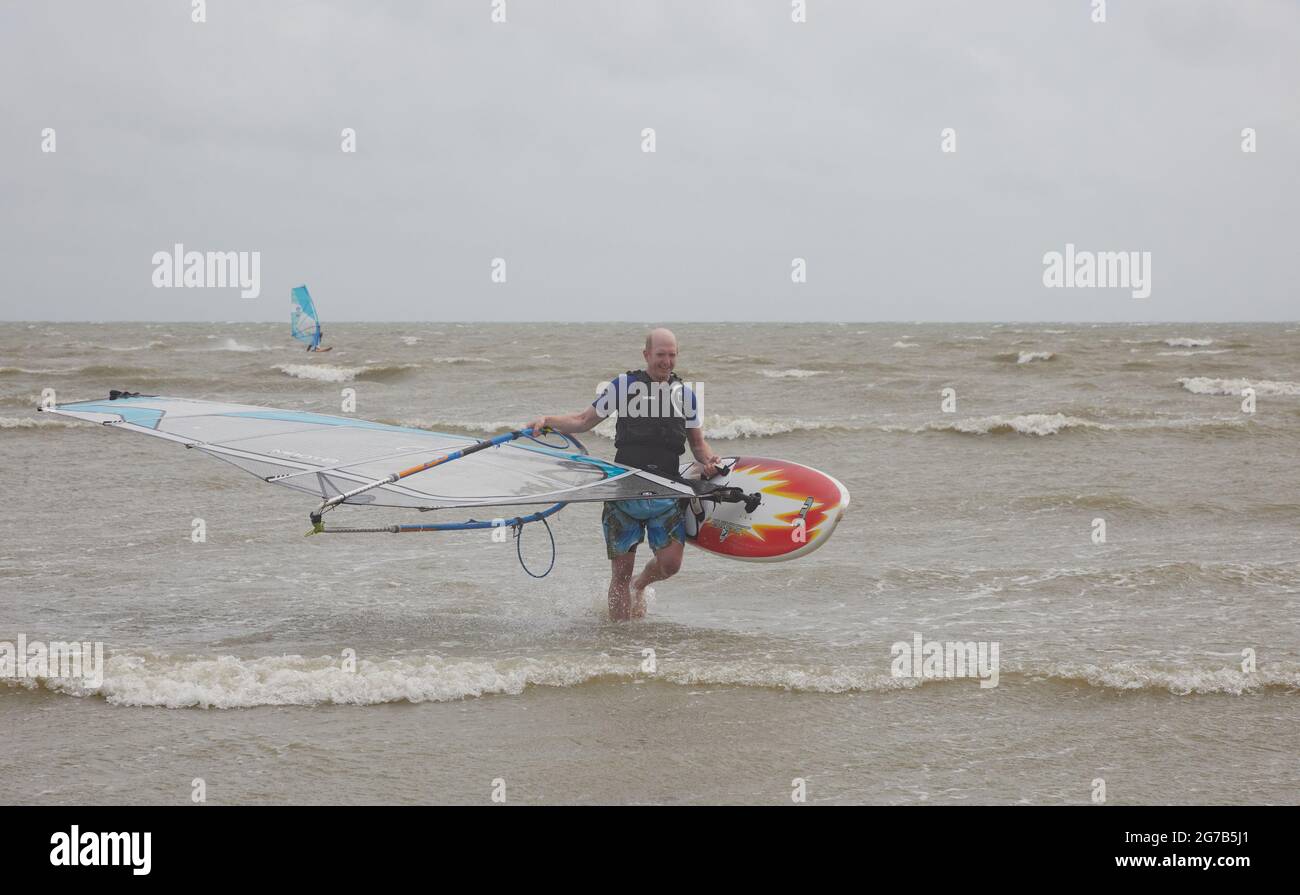 I surfboarders hanno visto attivi sulla costa meridionale del Regno Unito in un vento nell'estate del 2021. Foto Stock