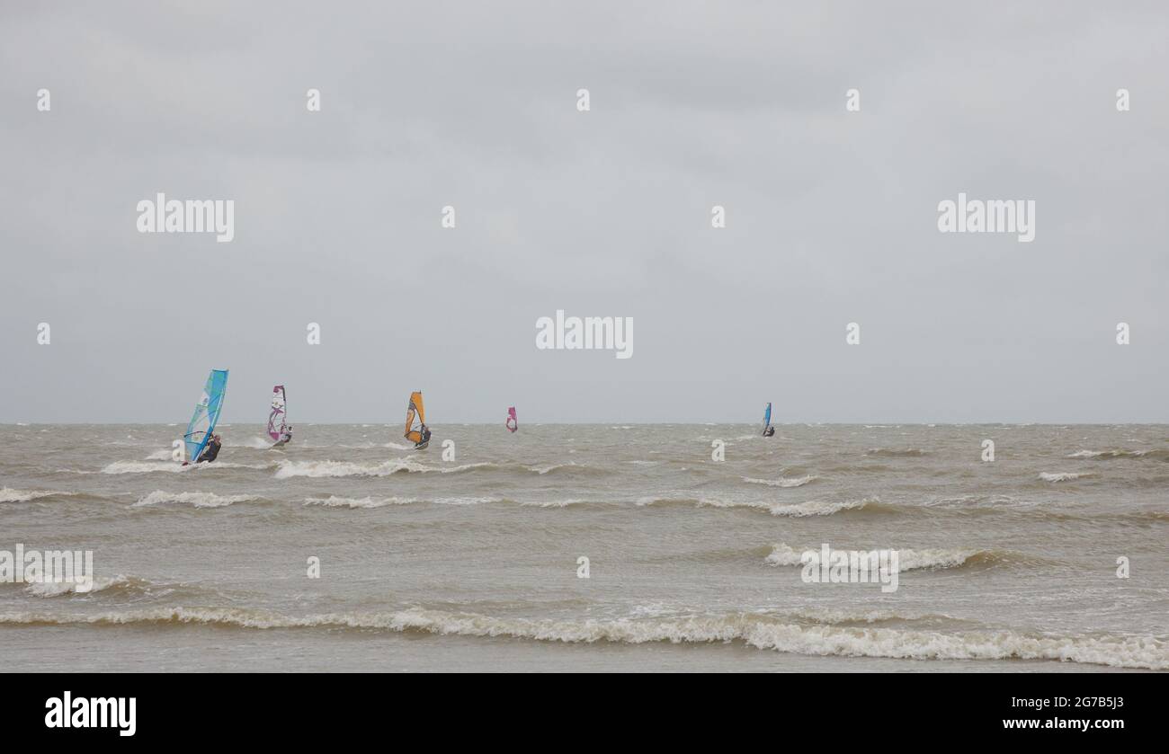 I surfboarders hanno visto attivi sulla costa meridionale del Regno Unito in un vento nell'estate del 2021. Foto Stock
