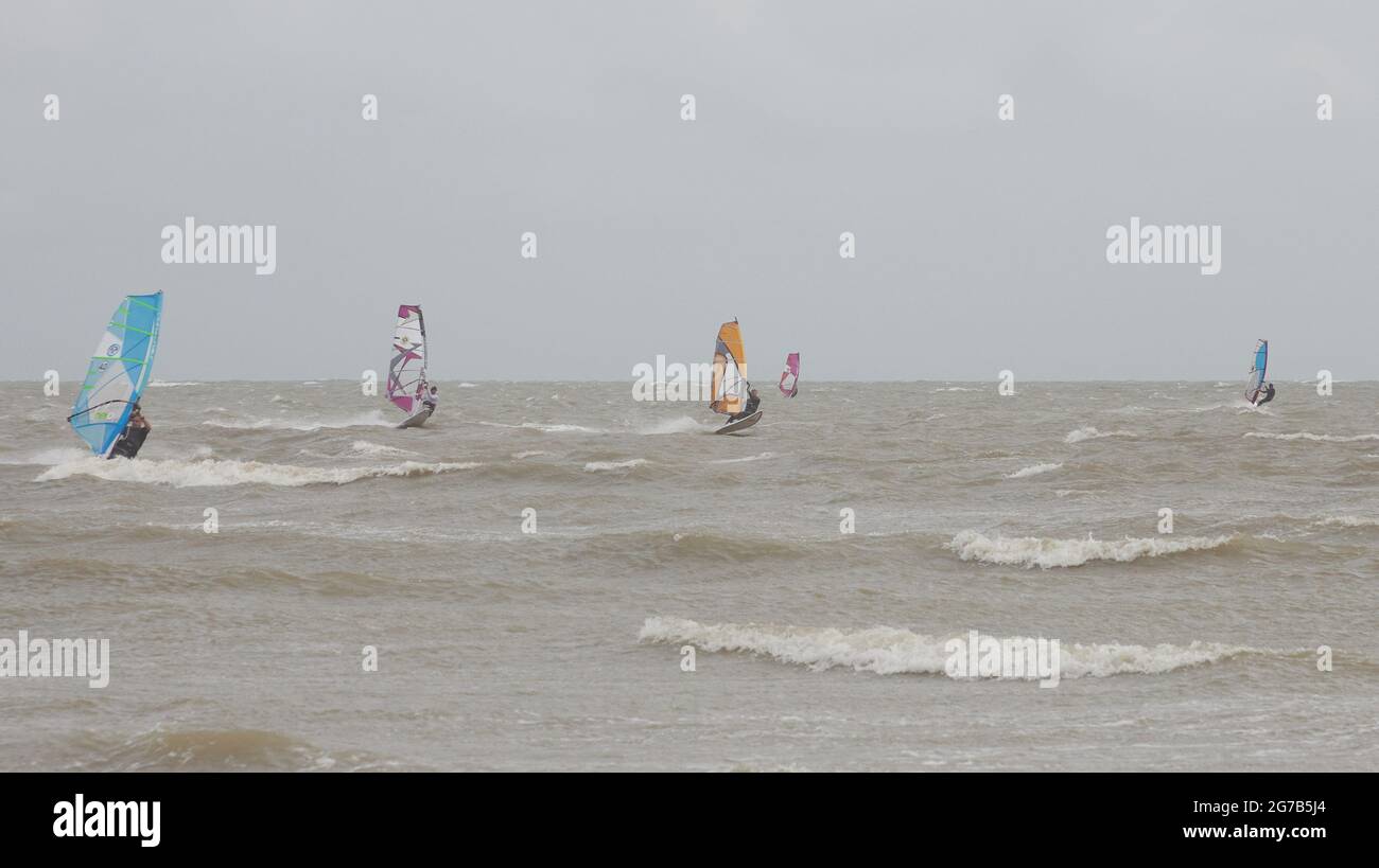 I surfboarders hanno visto attivi sulla costa meridionale del Regno Unito in un vento nell'estate del 2021. Foto Stock