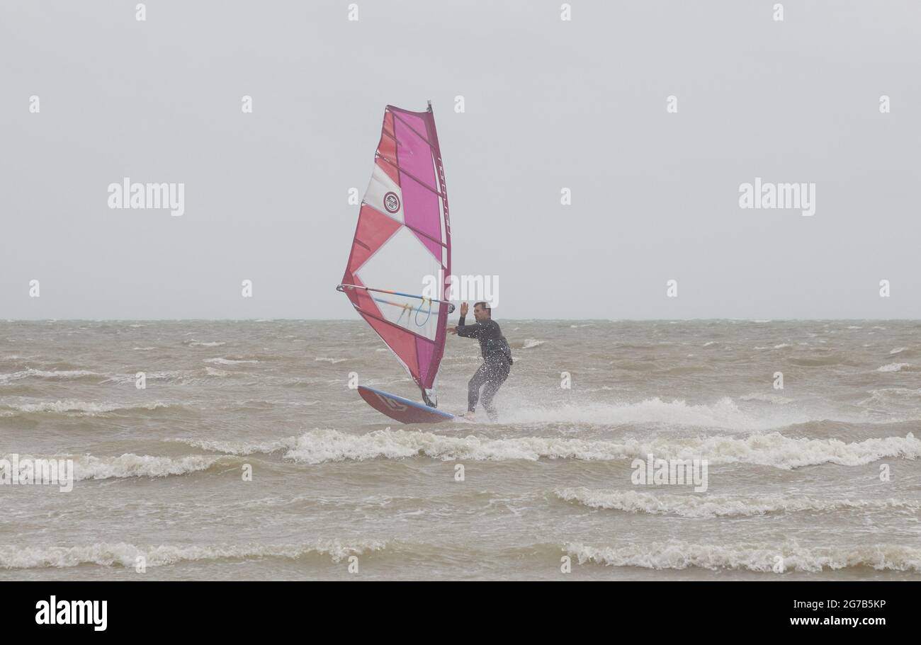 I surfboarders hanno visto attivi sulla costa meridionale del Regno Unito in un vento nell'estate del 2021. Foto Stock