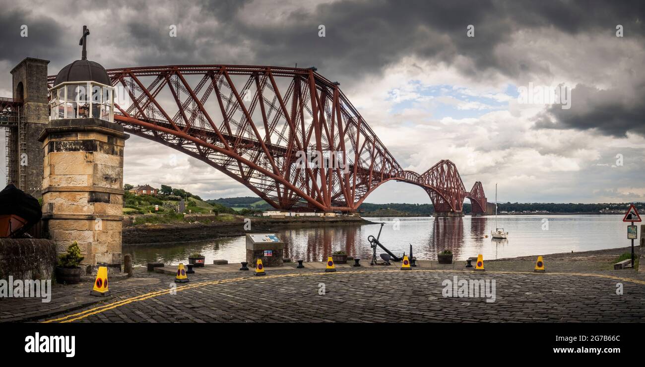 Situata all'ombra del Forth Bridge, la torre faro del porto di Robert Stevenson, costruita nel 1817, è il più piccolo faro funzionante del mondo. Foto Stock