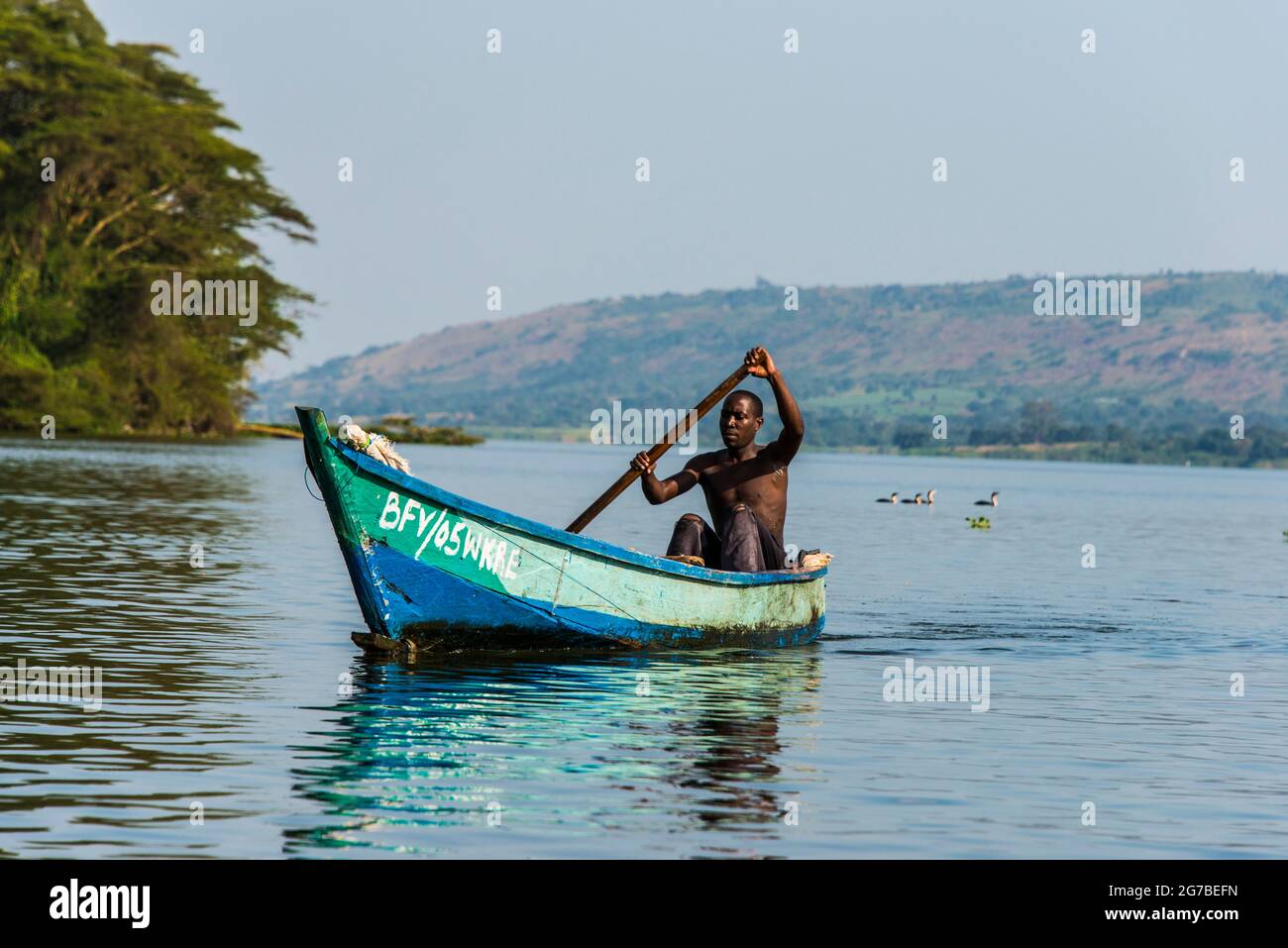 Pescatore locale in canoa a Jinja, Uganda, Africa Foto Stock