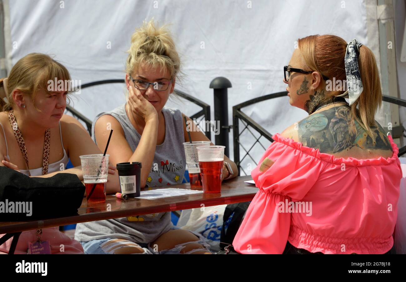Donna tatuata con gli amici al mercato estivo. Foto Stock