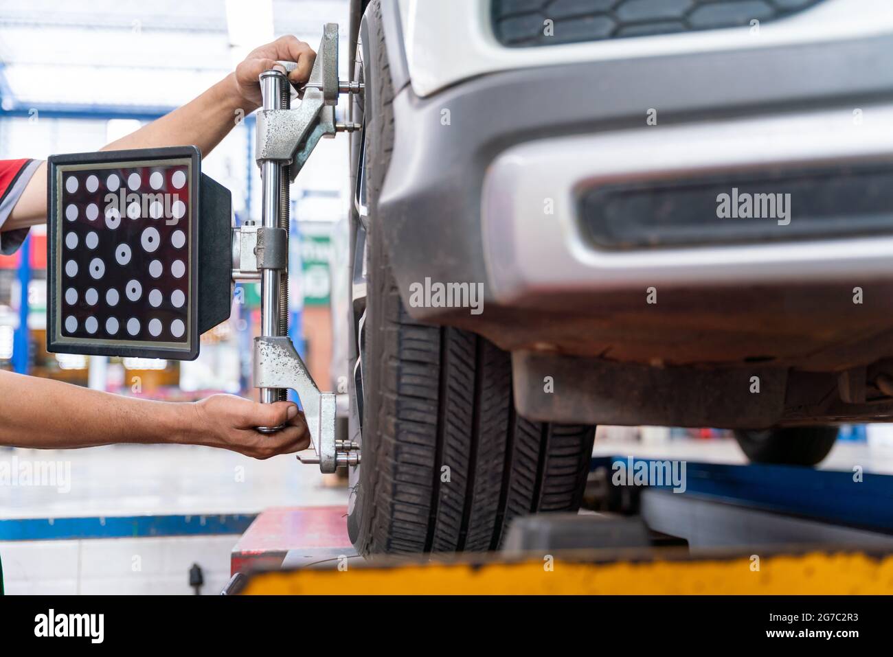 auto mechic installare equilibratrice ruota auto tarare con catarifrangente laser fissare su ogni pneumatico per centrare la regolazione di guida. Equilibratura della macchina gommata a. Foto Stock