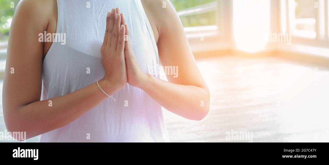 Le donne asiatiche stanno praticando lo yoga. Indossare abiti bianchi all'interno. Lo yoga è praticare la meditazione e determinare il respiro. Salute fitness concep Foto Stock