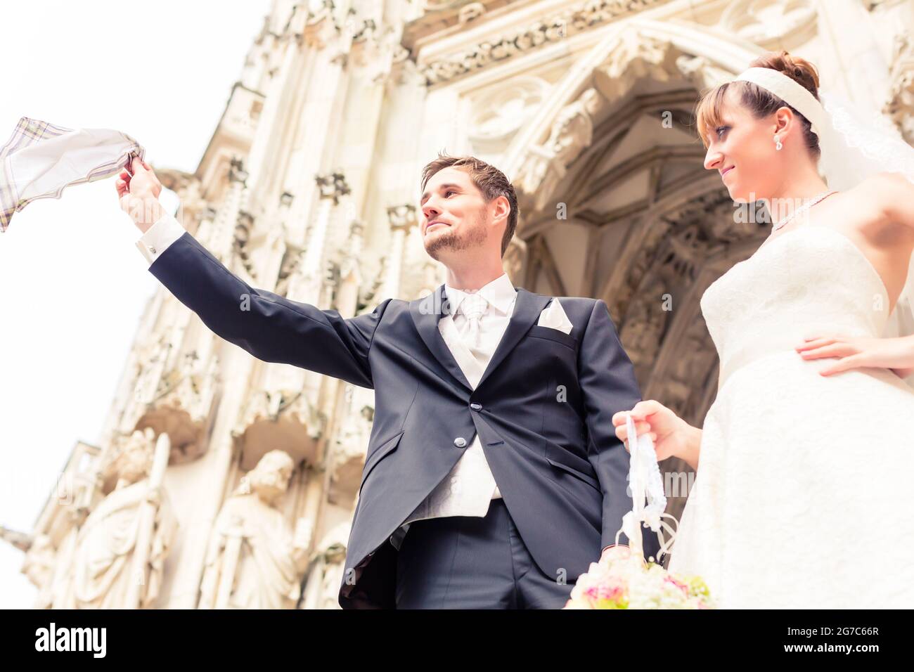 Sposa sorridente guardando sposo battenti igienico in aria esterna Foto Stock