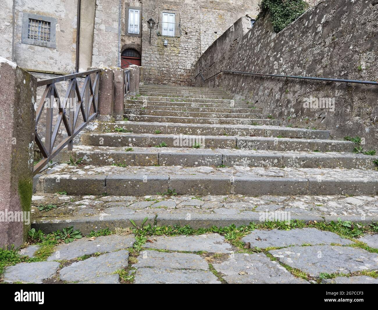 Foto in prospettiva dal basso di una grande scalinata in pietra tra le strade di una piccola città. Foto Stock