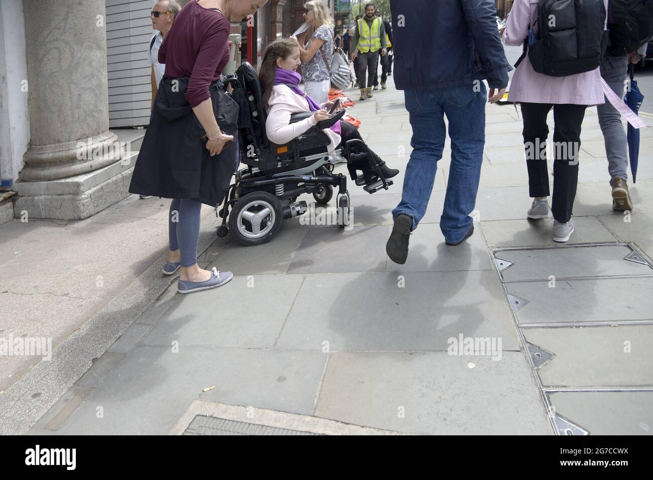 Londra, Inghilterra, Regno Unito. Donna su sedia a rotelle motorizzata a Whitehall, Westminster Foto Stock