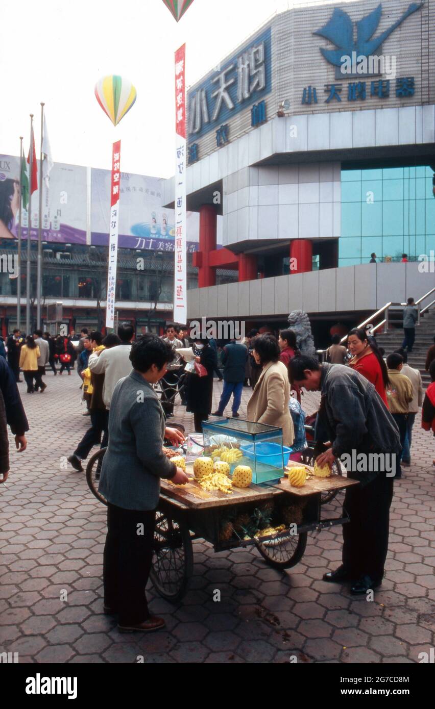 Ein Obststand bietet frische ananas vor einem Einkaufszentrum a Shanghai, Cina 1998. Una cabina di frutta che offre ananas freschi di fronte ad un centro commerciale a Shanghai, Cina 1998. Foto Stock
