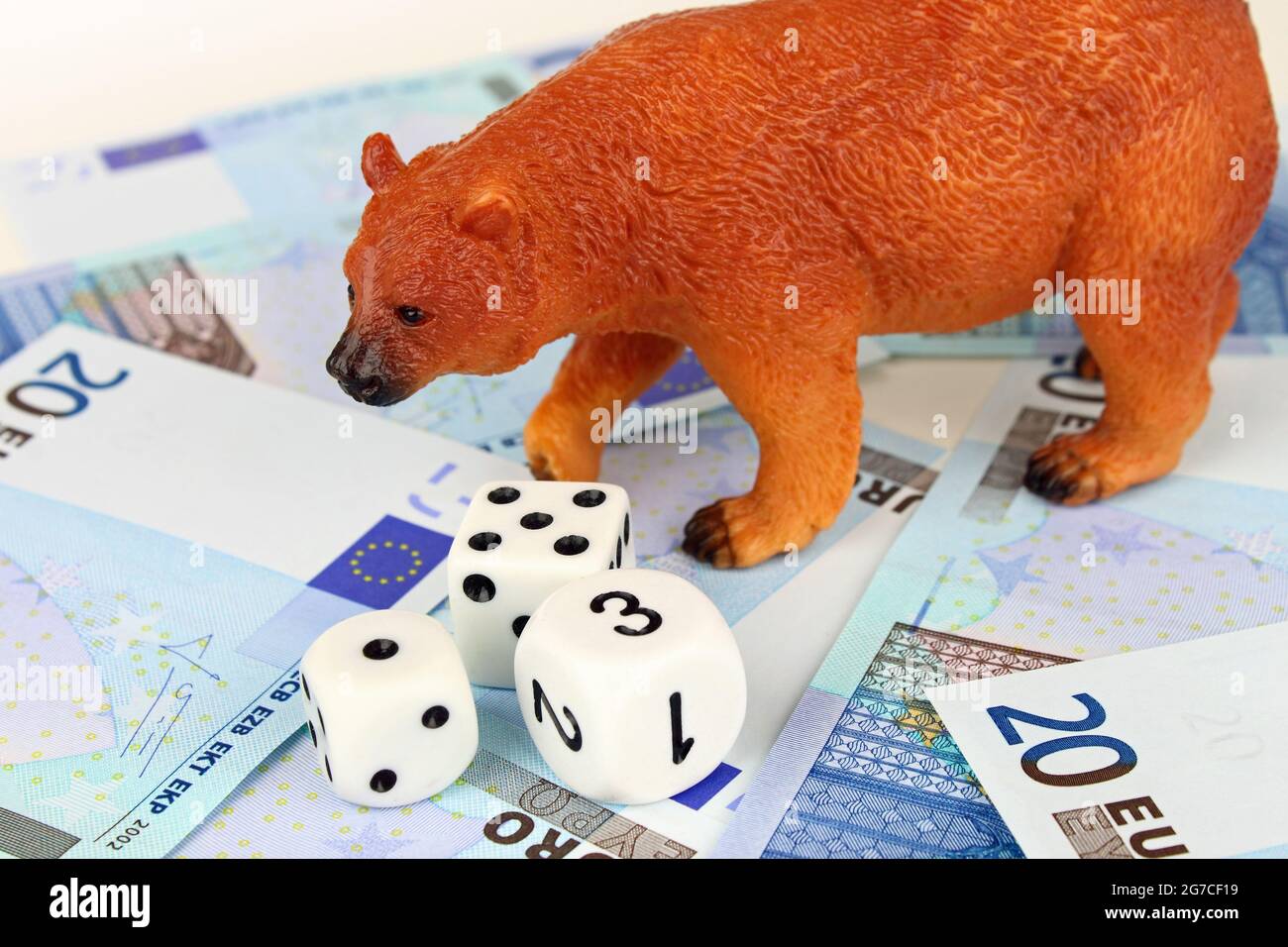 Un orso che gioca a dadi con denaro in euro. Foto Stock