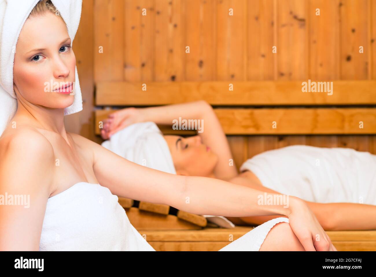 Due donne in wellness spa relax nella sauna in legno Foto Stock