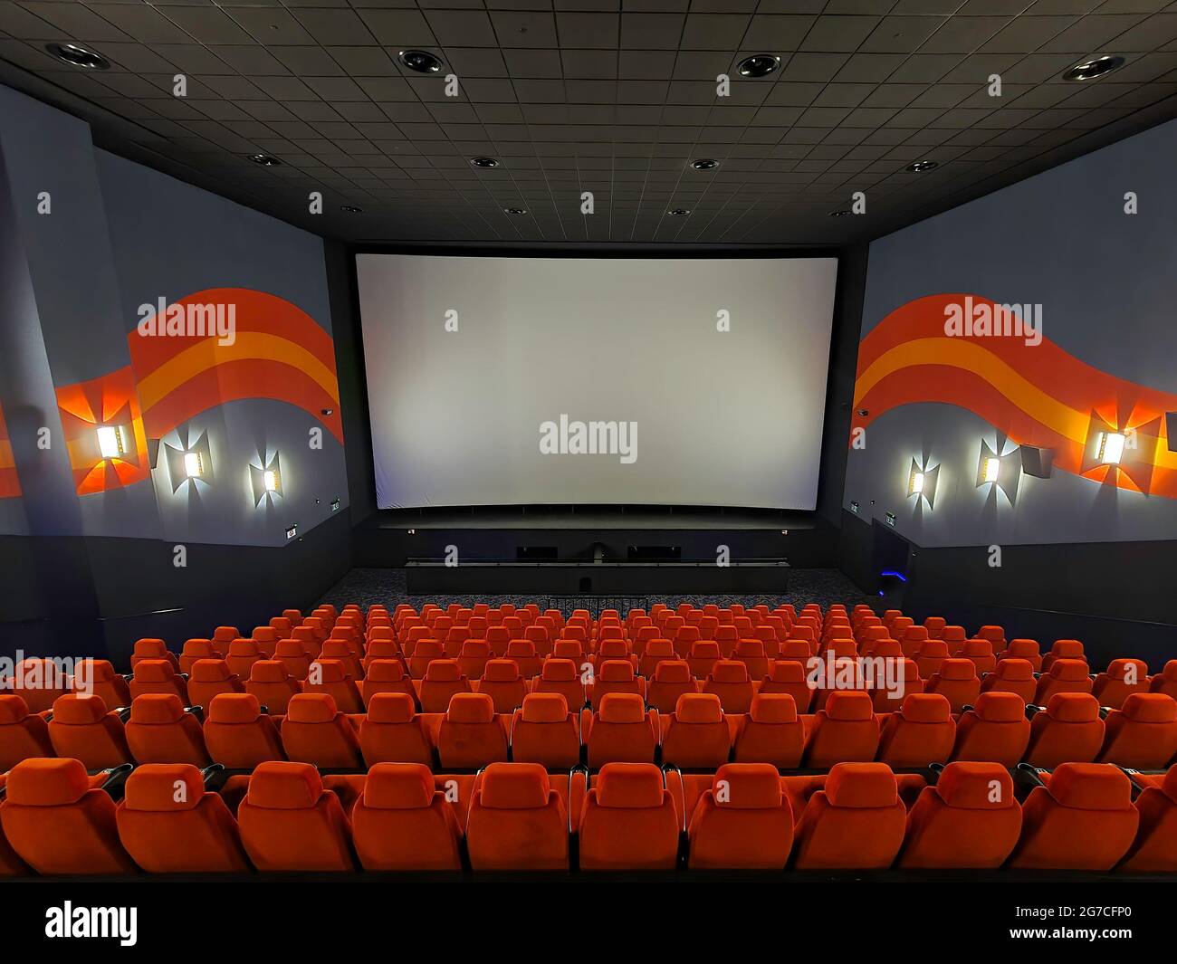 All'interno del grande cinema. Posti vuoti in attesa del filmato sullo schermo bianco. Il testo o l'immagine sullo schermo bianco. Foto Stock